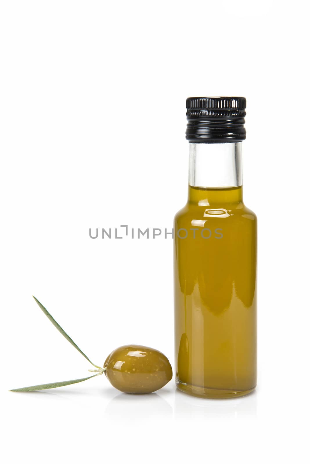 Glass bottle of premium virgin olive oil and some olives with leaves isolated on a white background