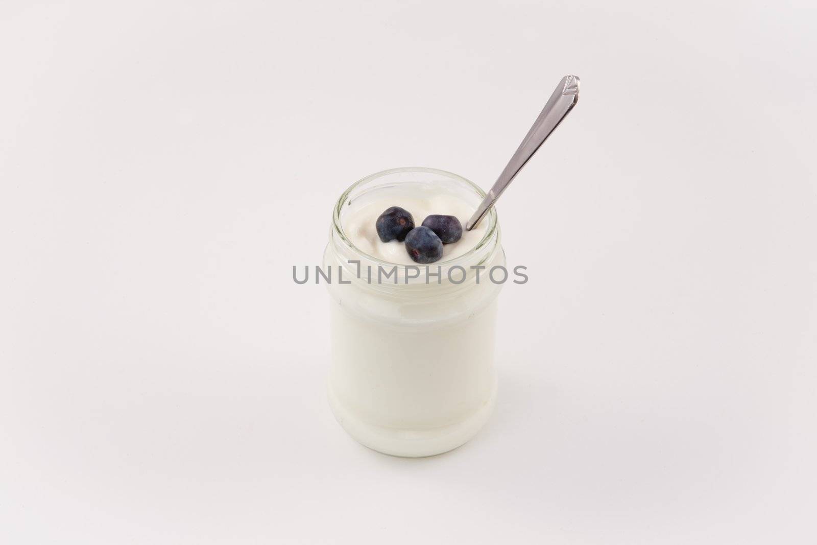 Pot of yoghurt with three blueberries by Wavebreakmedia