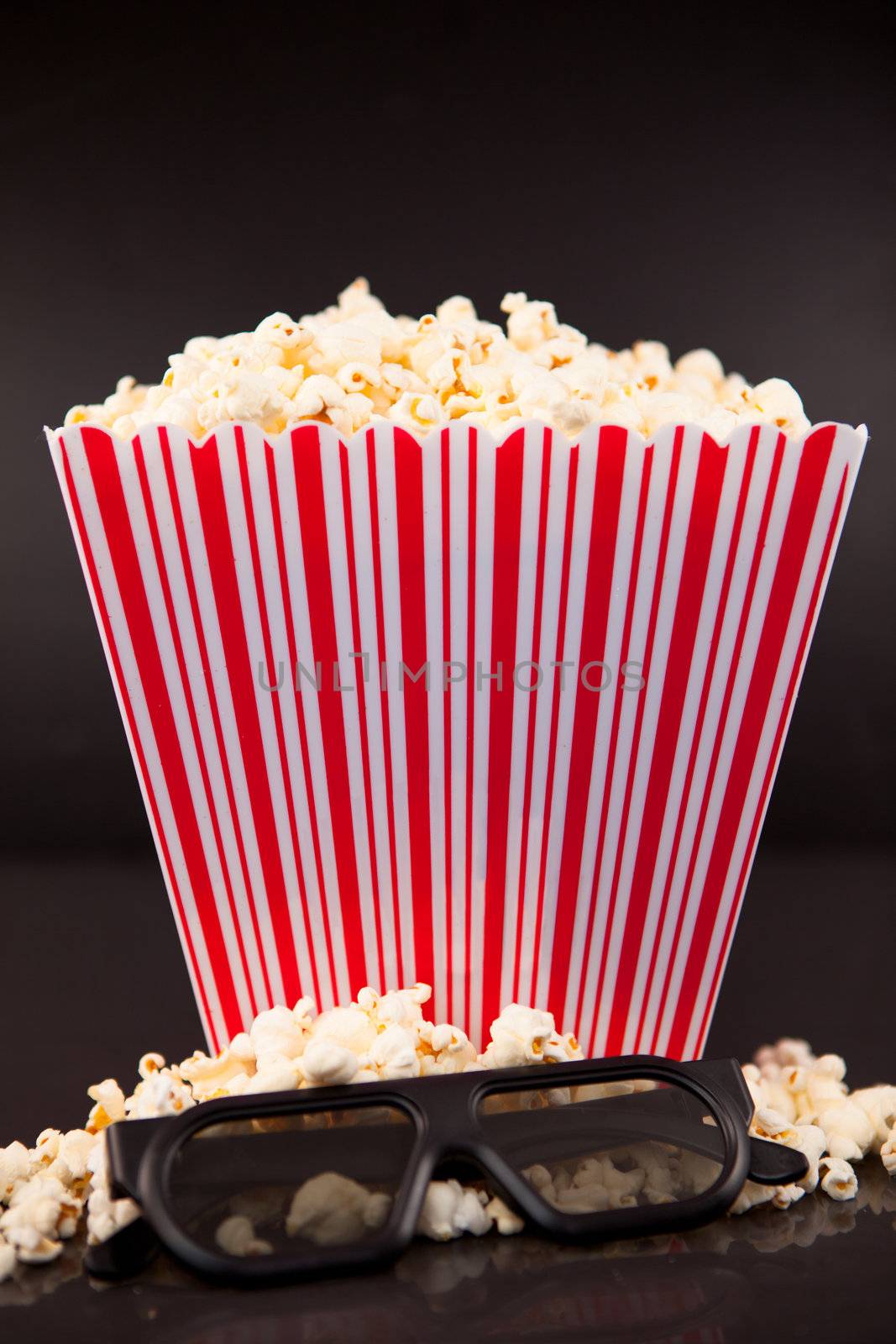 3D glasses on popcorn at the feet of a box of popcorn by Wavebreakmedia
