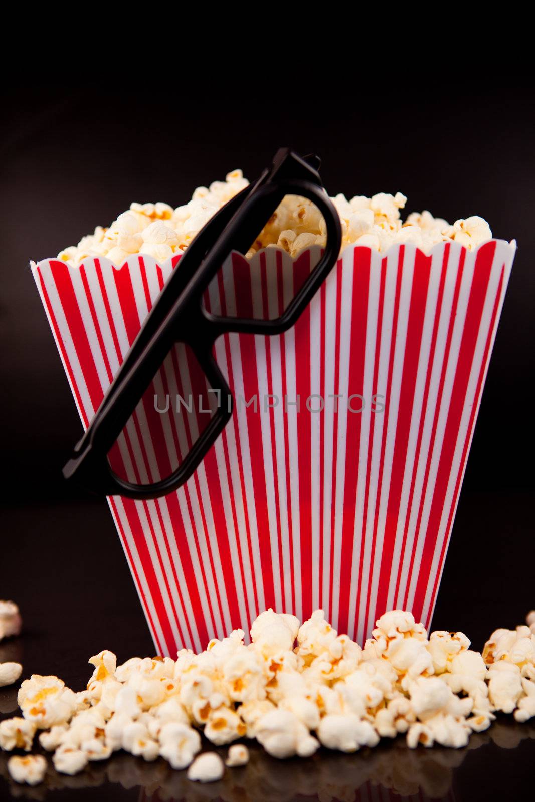 3D Glasses hanging on a box full of popcorn by Wavebreakmedia