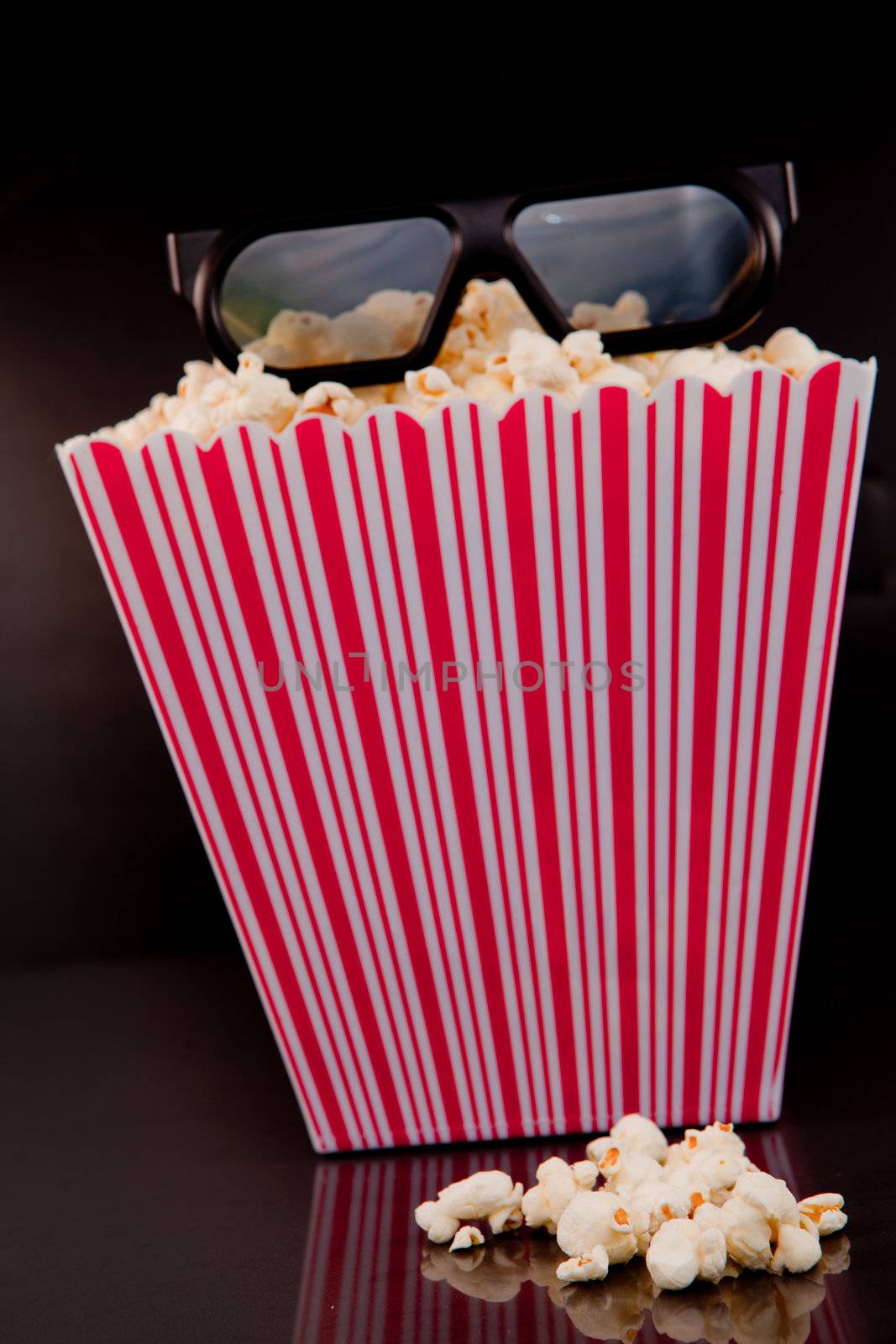3D glasses on a box of pop corn against a black background