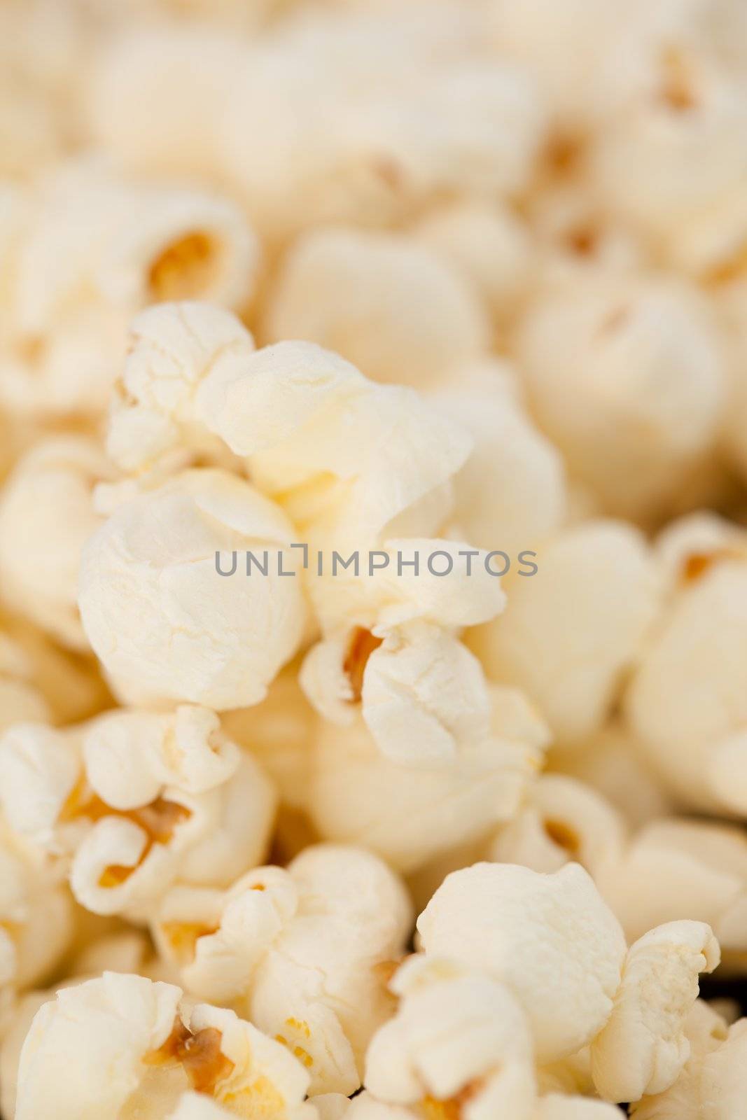 Close up on many blurred pop corn against a black background