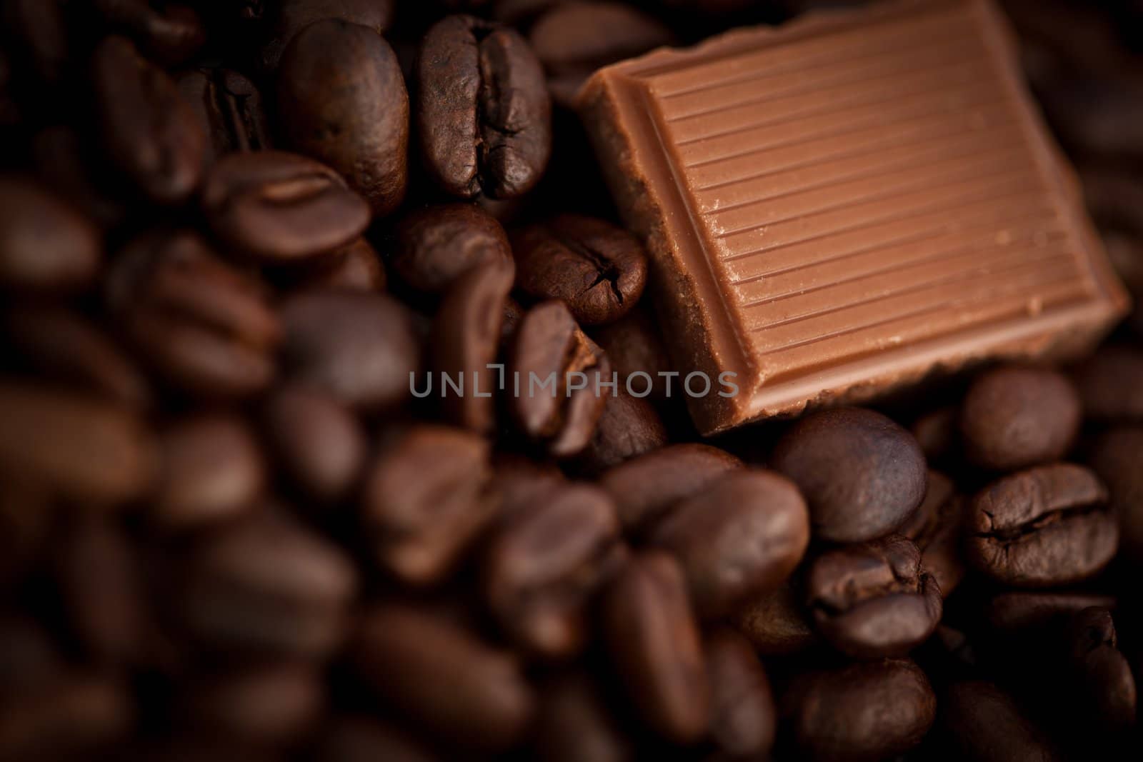 Close up of a piece of chocolate and coffee seeds together