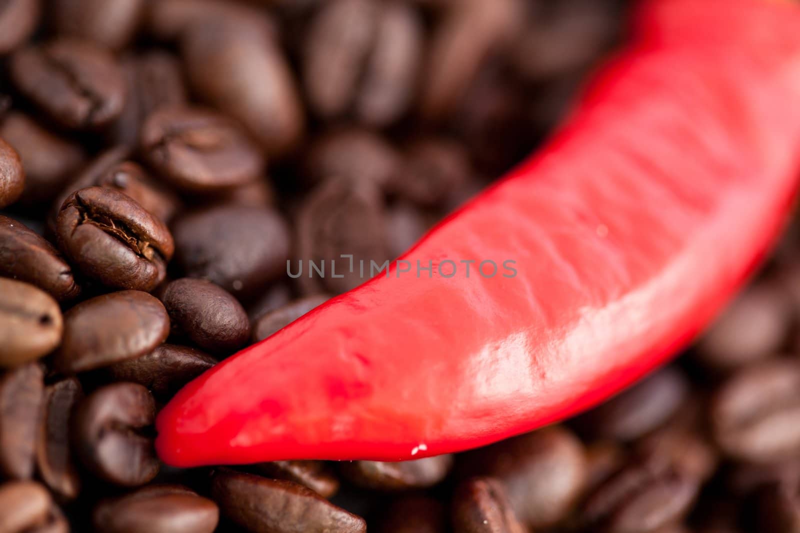 Close up of a red pepper and coffee beans together