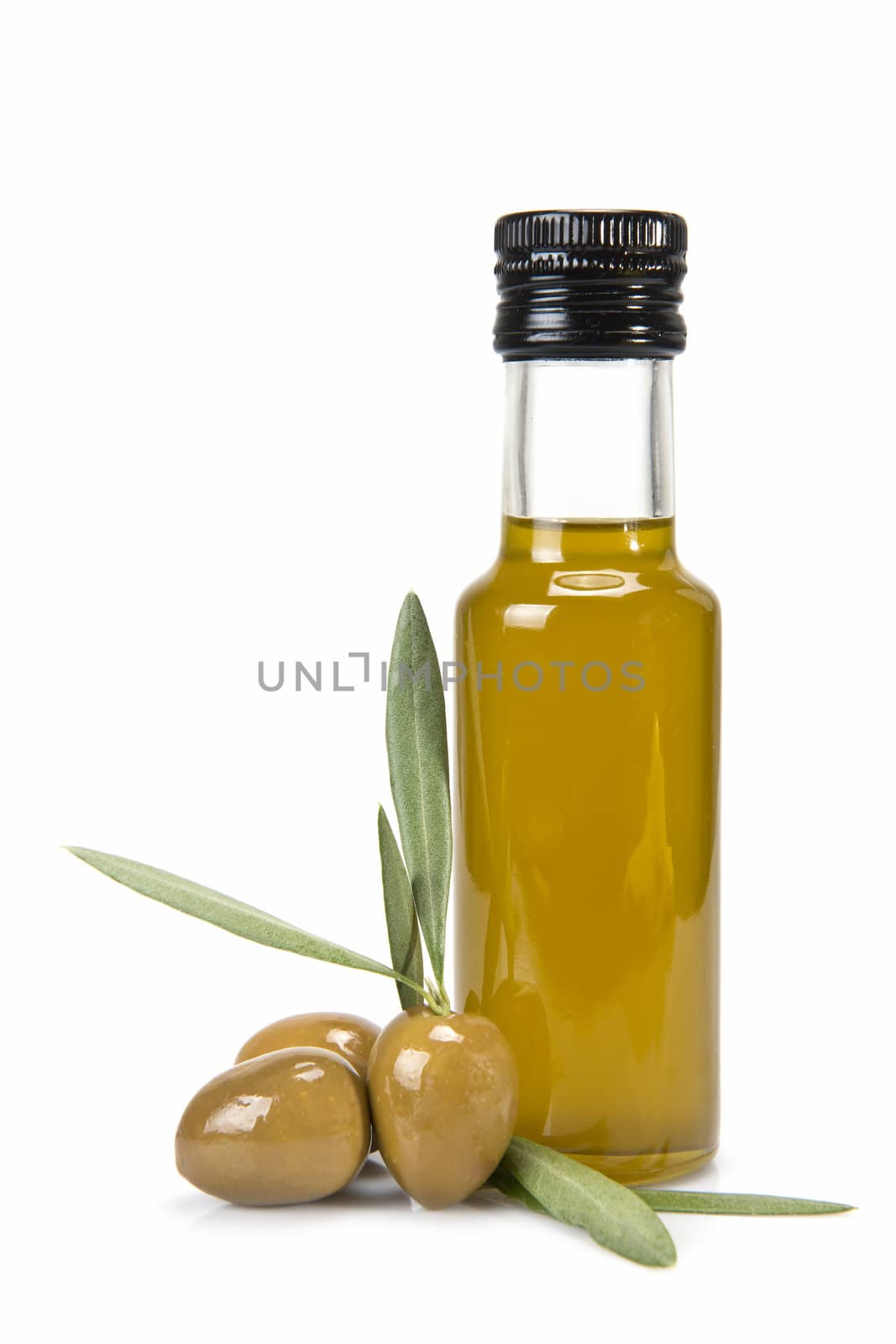 Glass bottle of premium virgin olive oil and some olives with leaves isolated on a white background