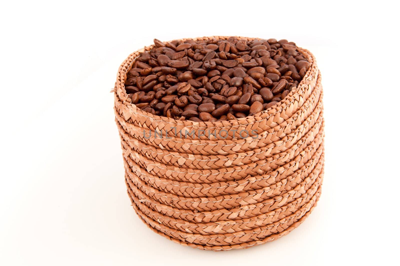 A basket full of roasted coffee seeds against a white background