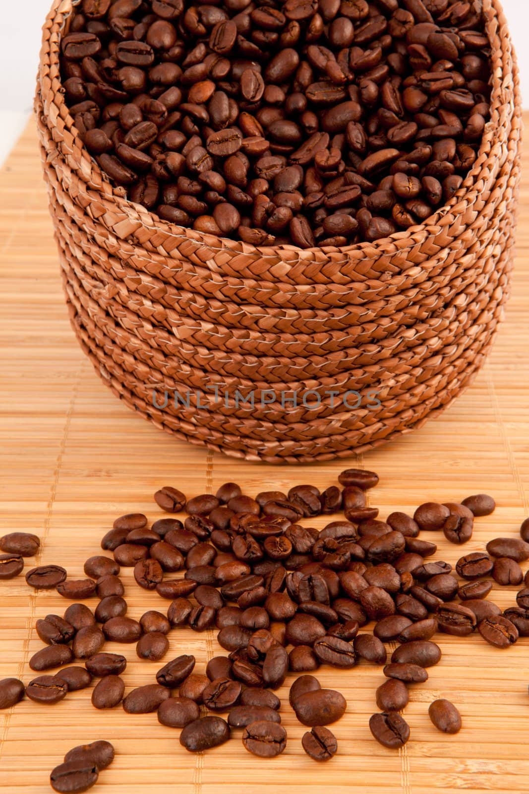 Close up of a basket filled with coffee seeds on a wooden tablec by Wavebreakmedia