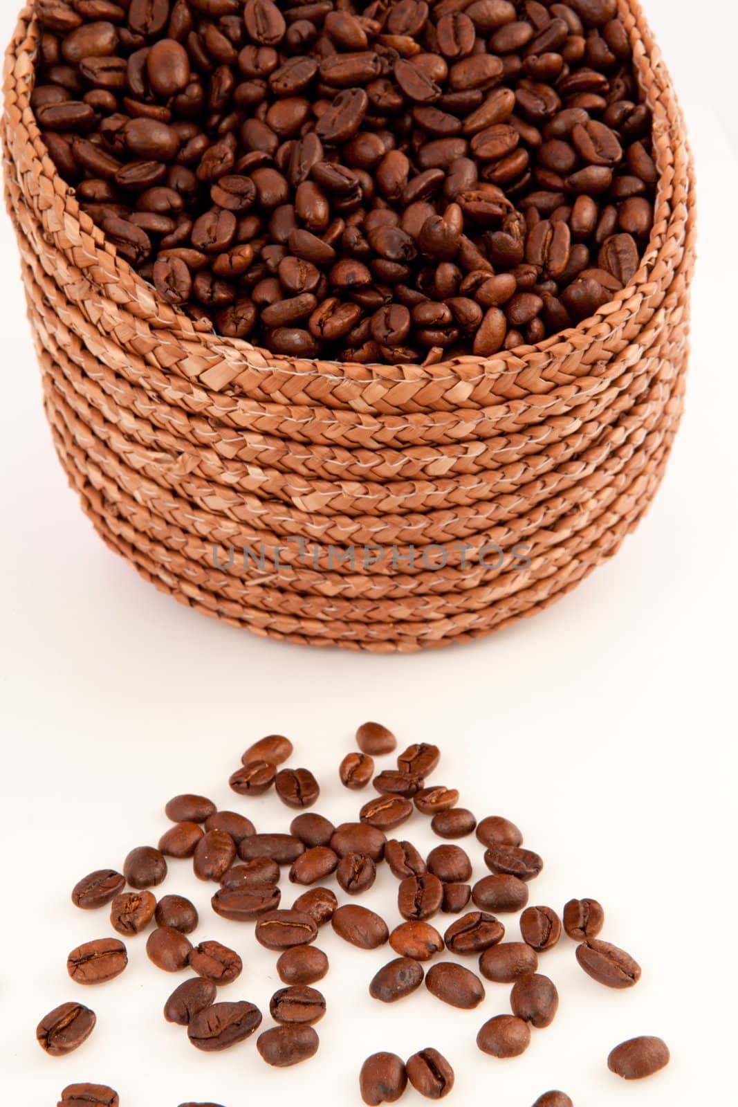 Close up of a basket filled with coffee seeds against a white background