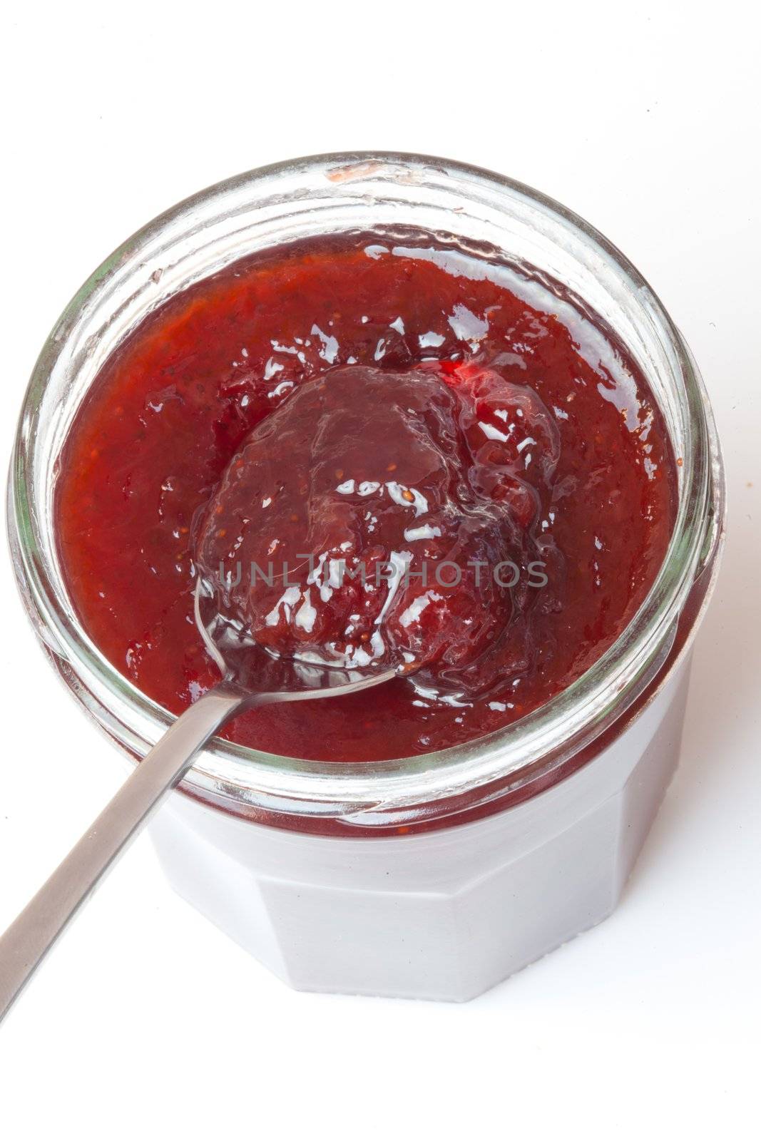 Jar of jam open against a white background