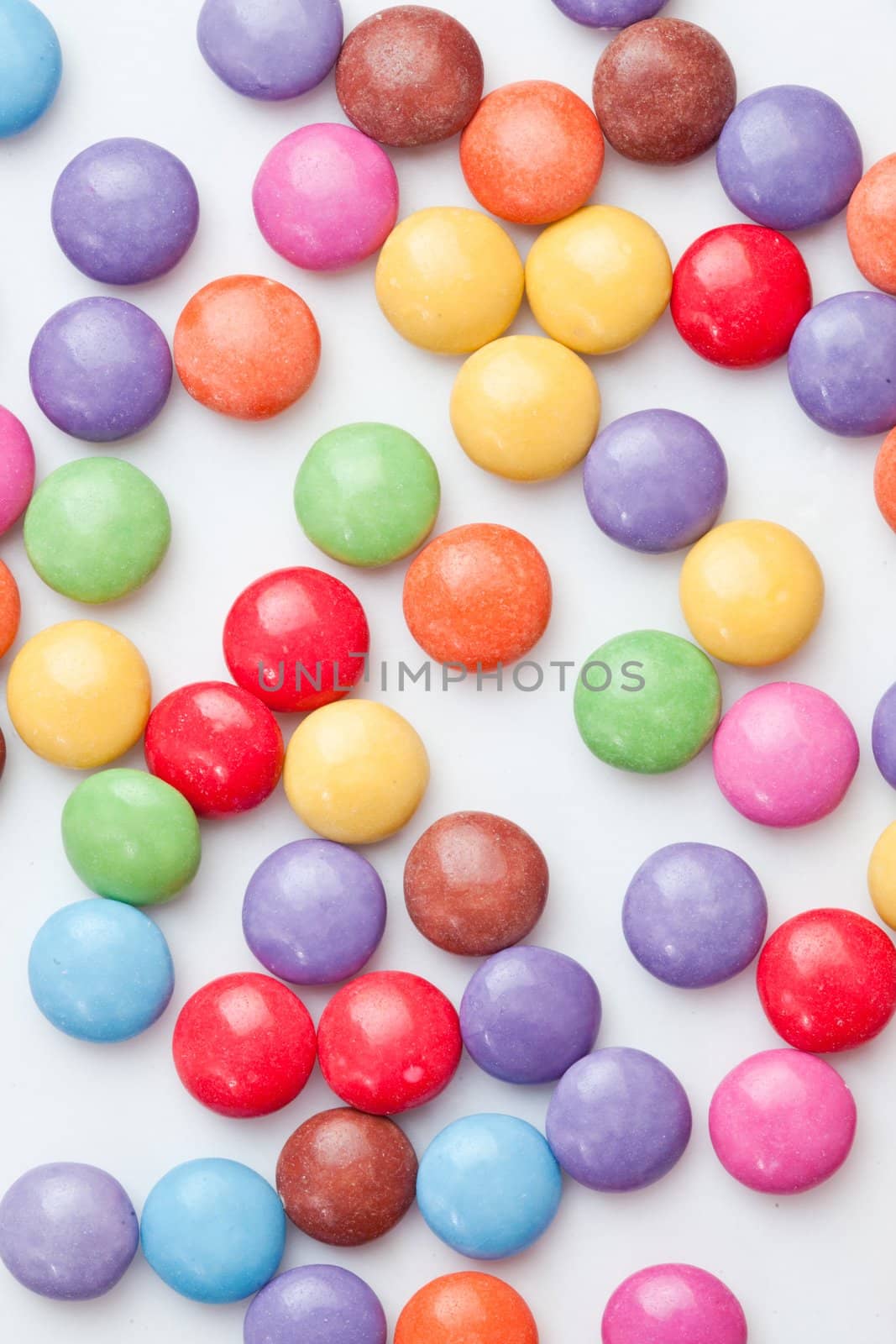 Chocolate candies multi coloured against a white background
