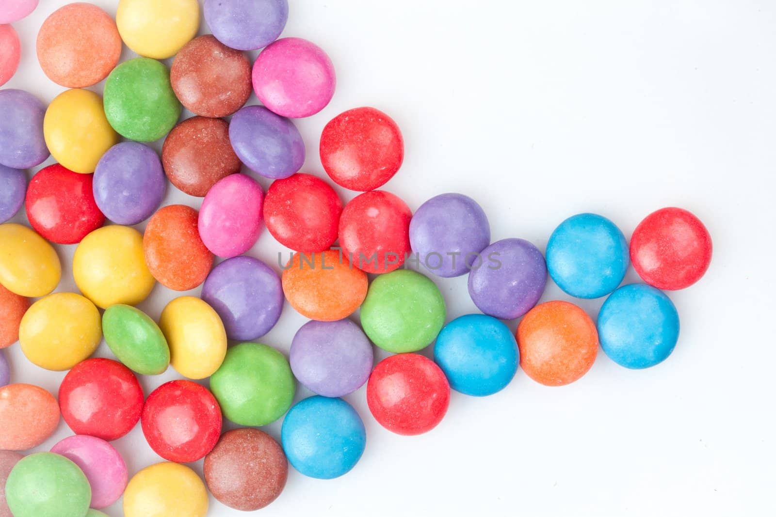 Multicolored candies against a white background