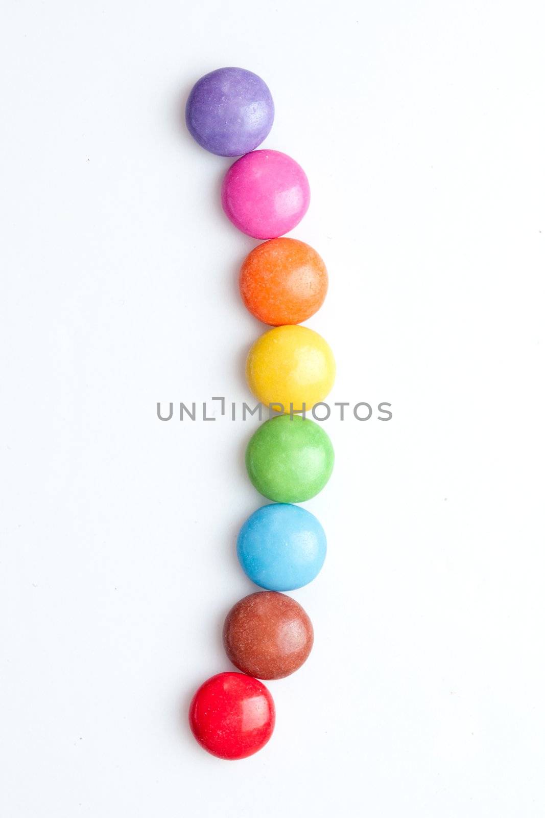 Chocolate candies in a line against a white background