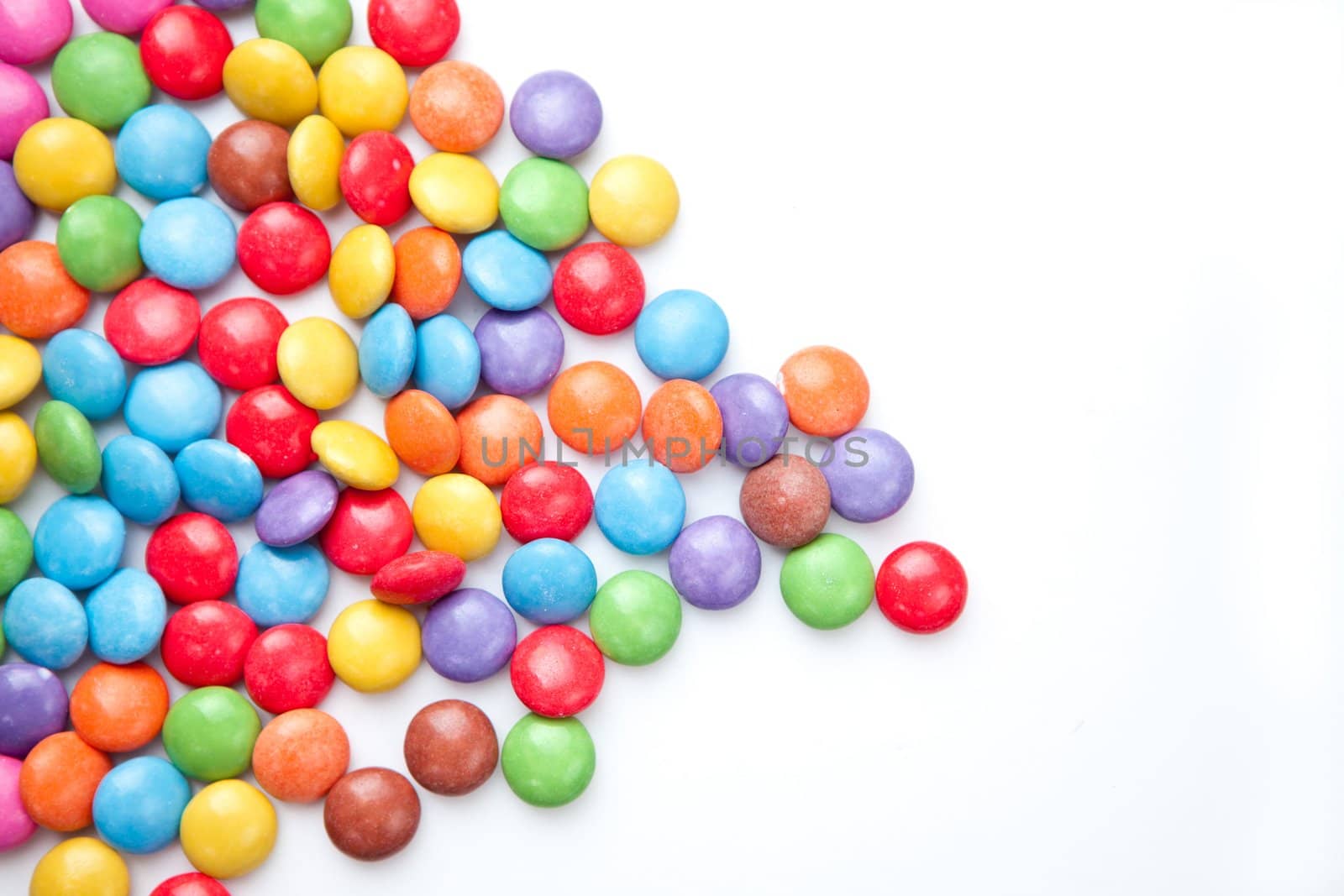 Heap of candies multi coloured against a white background