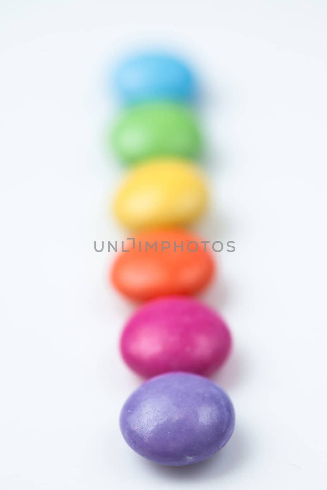 Rank of candies multi coloured against a white background