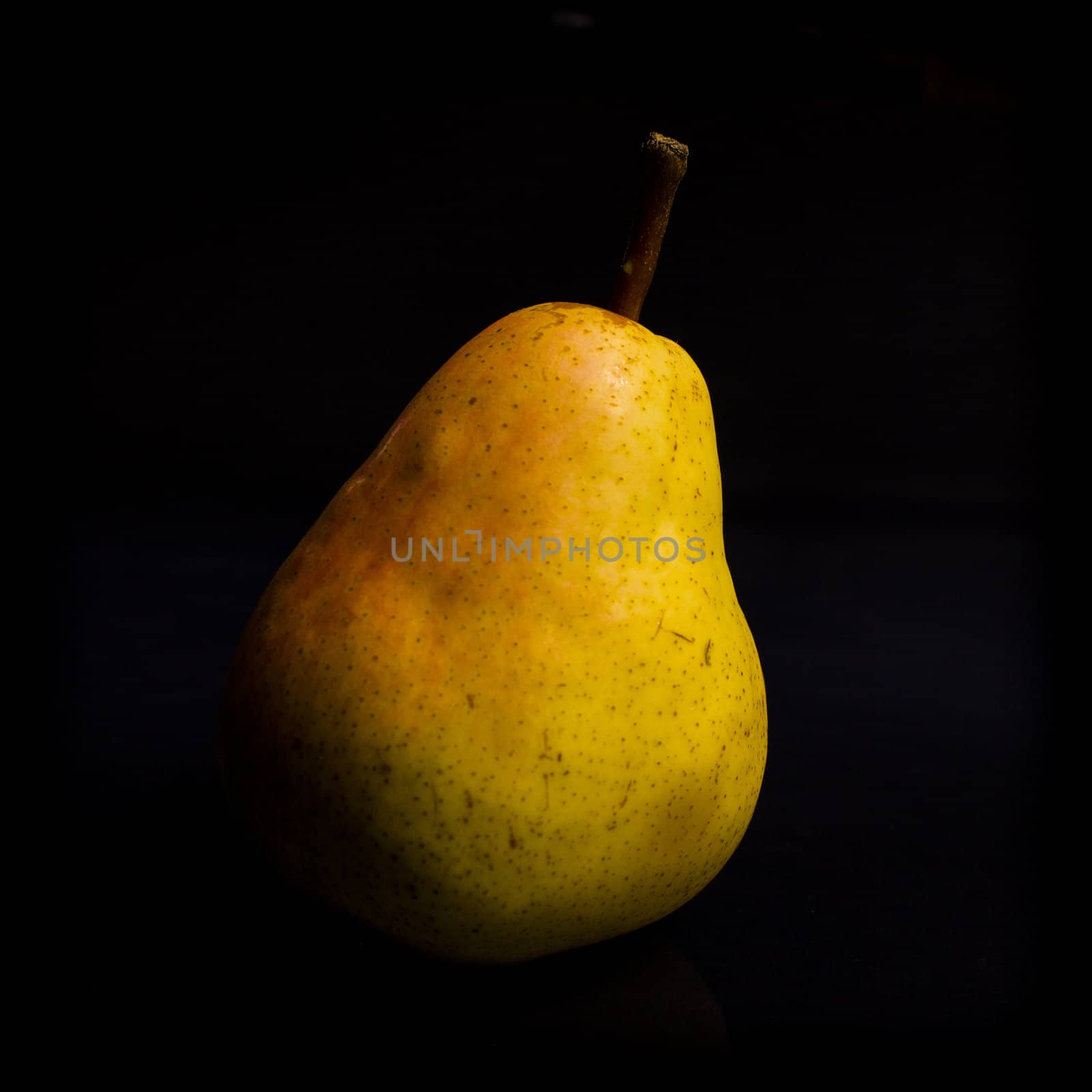 One fresh Pear on black background with reflection