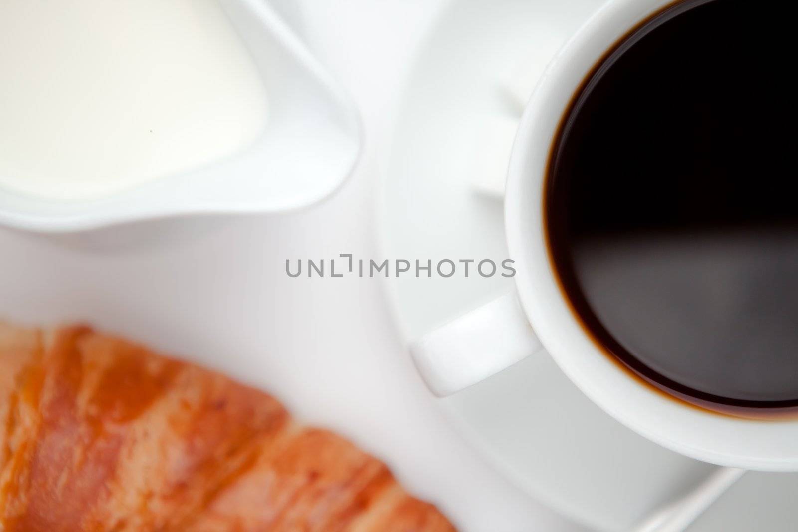 Coffee with croissant against a white background