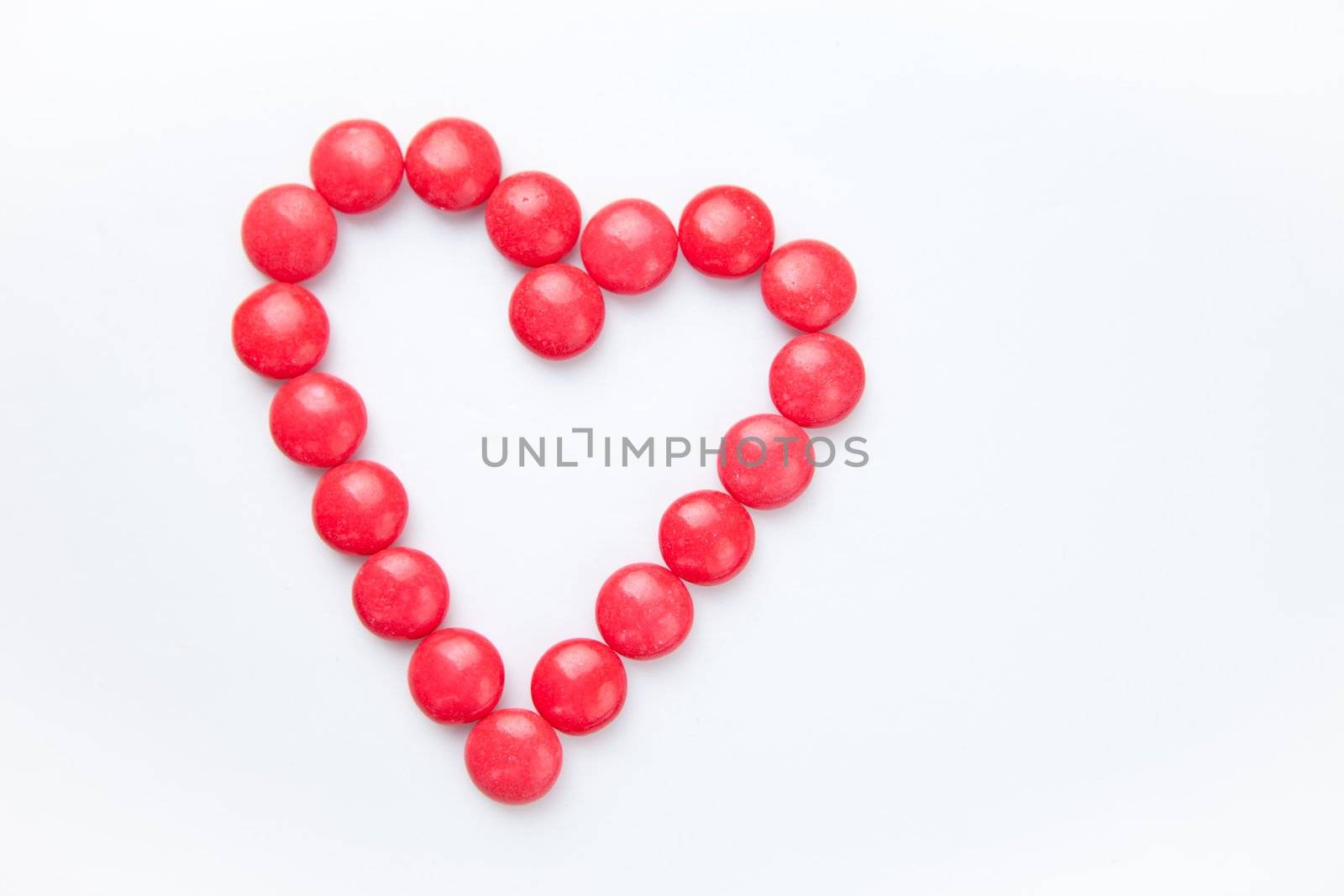 Heart of candies against a white background