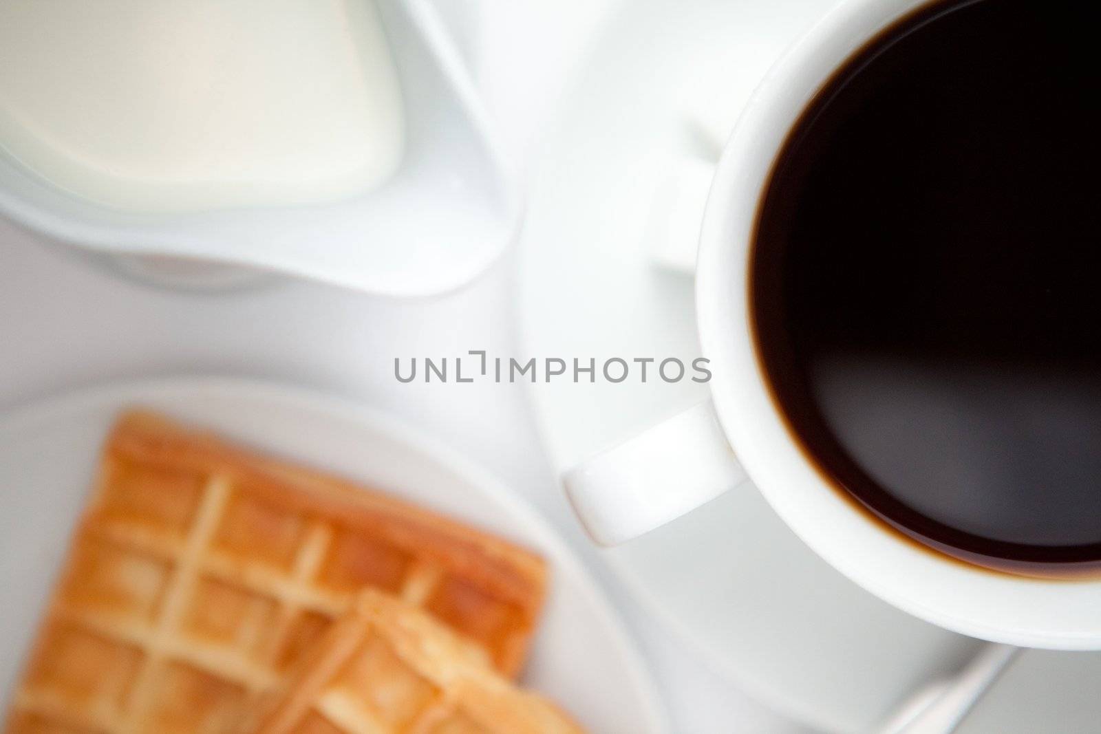 Cup of coffee with waffles against a white  background