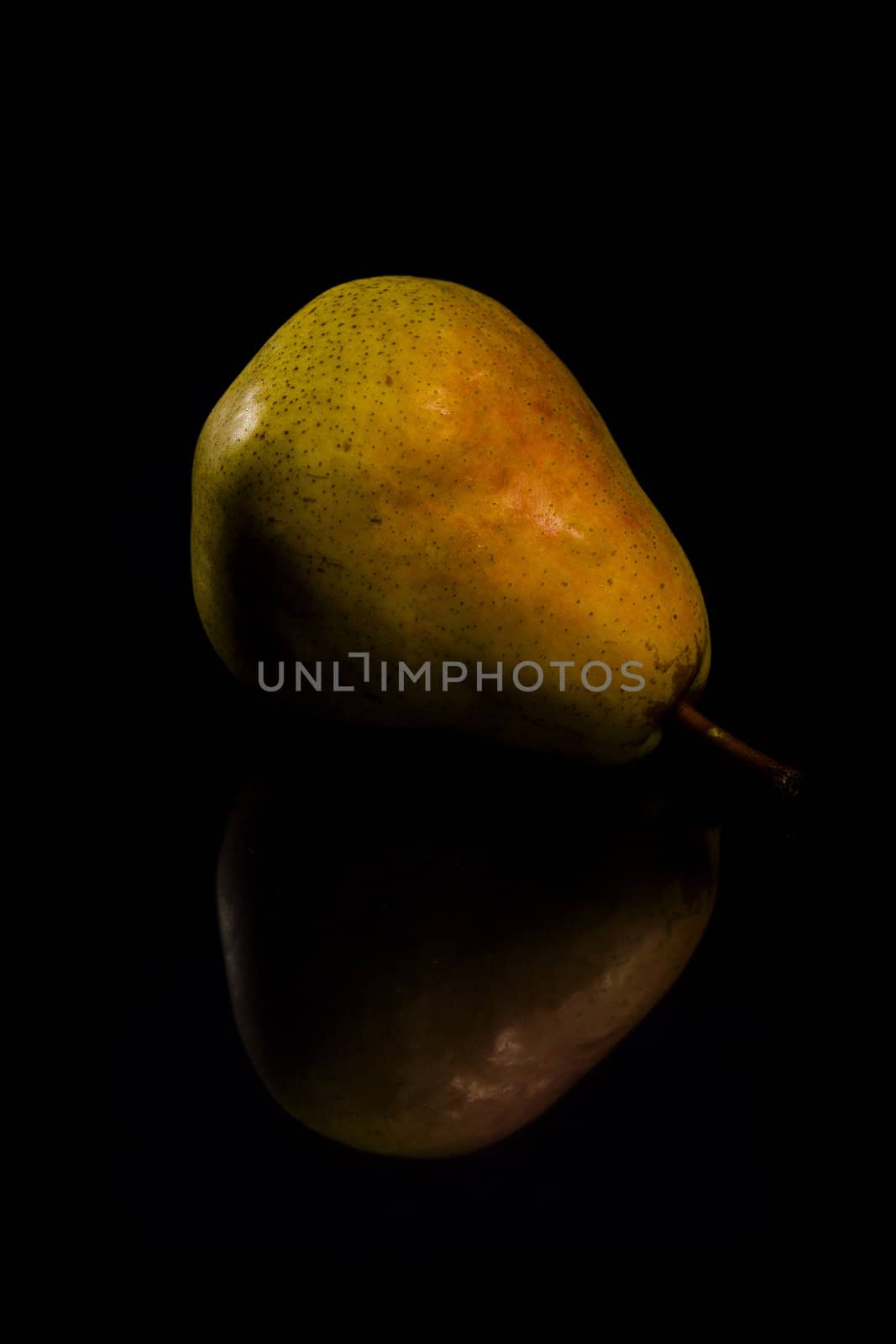 One fresh Pear on black background with reflection