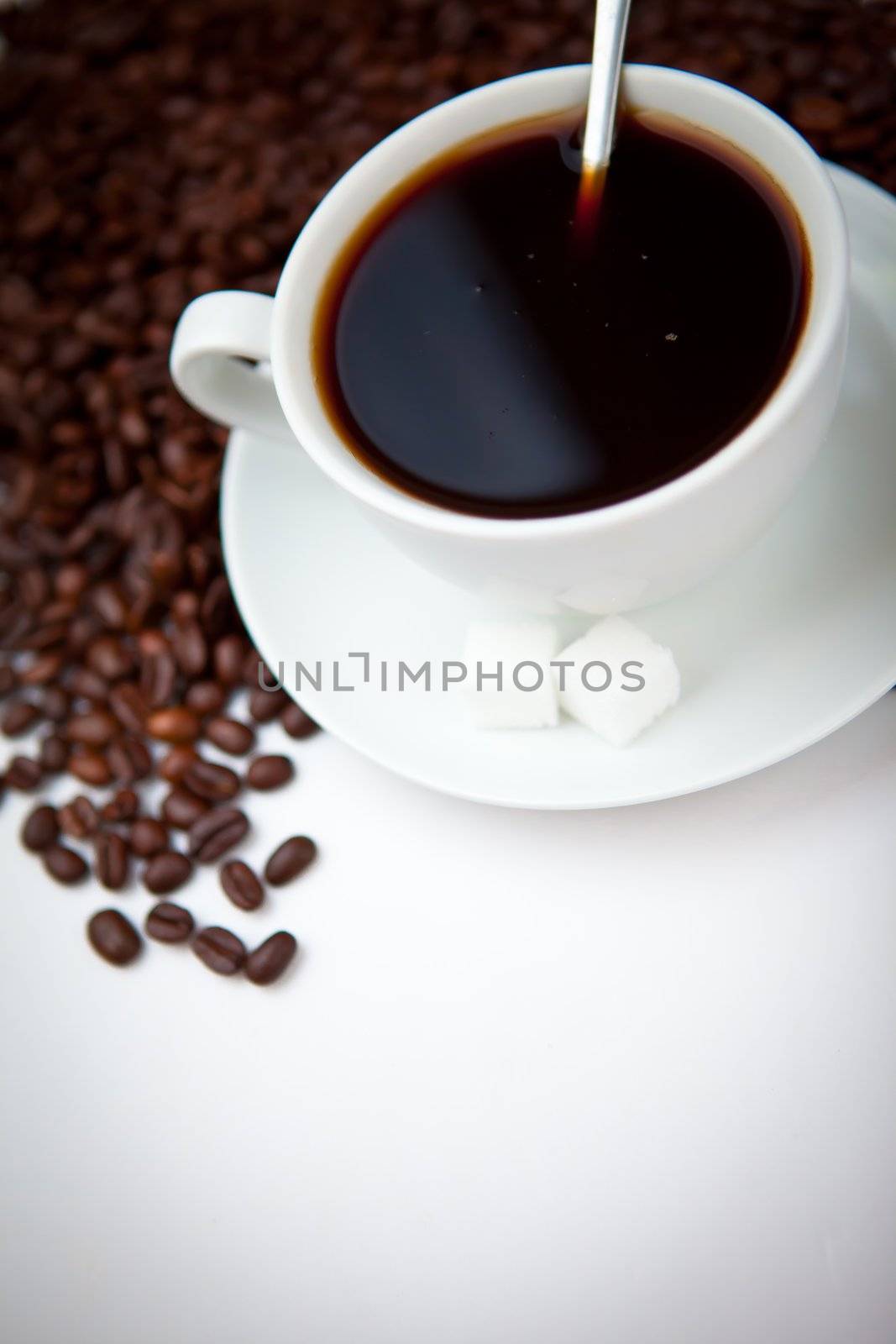 Black coffee with beans against a white background