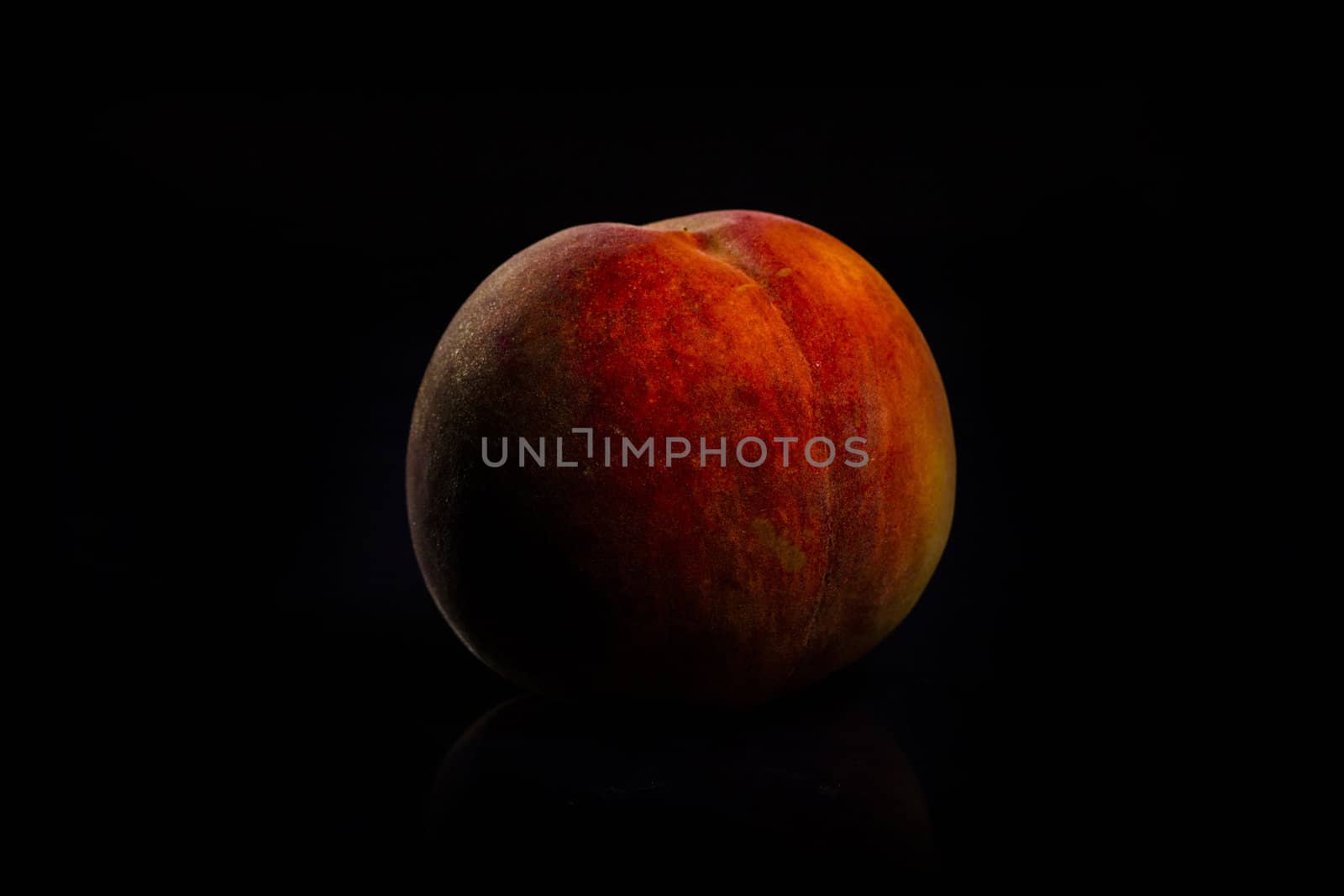 One fresh Peach on black background with reflection