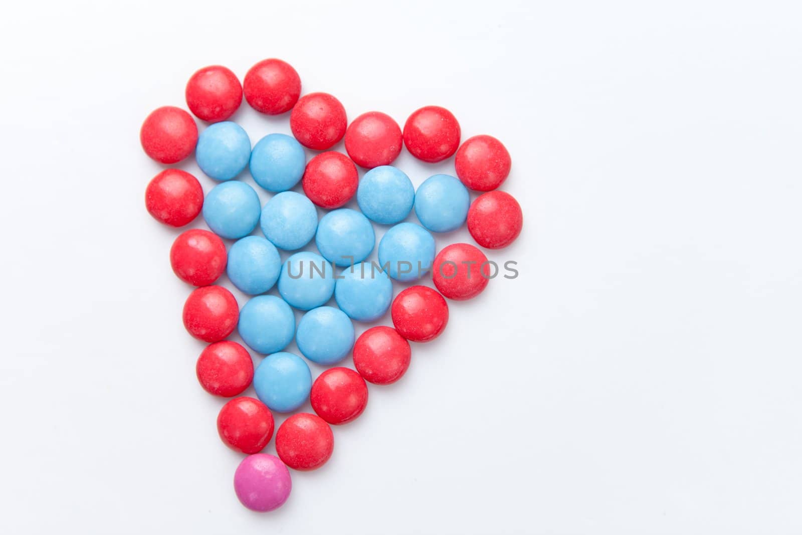 Heart of  chocolate candies against a white background