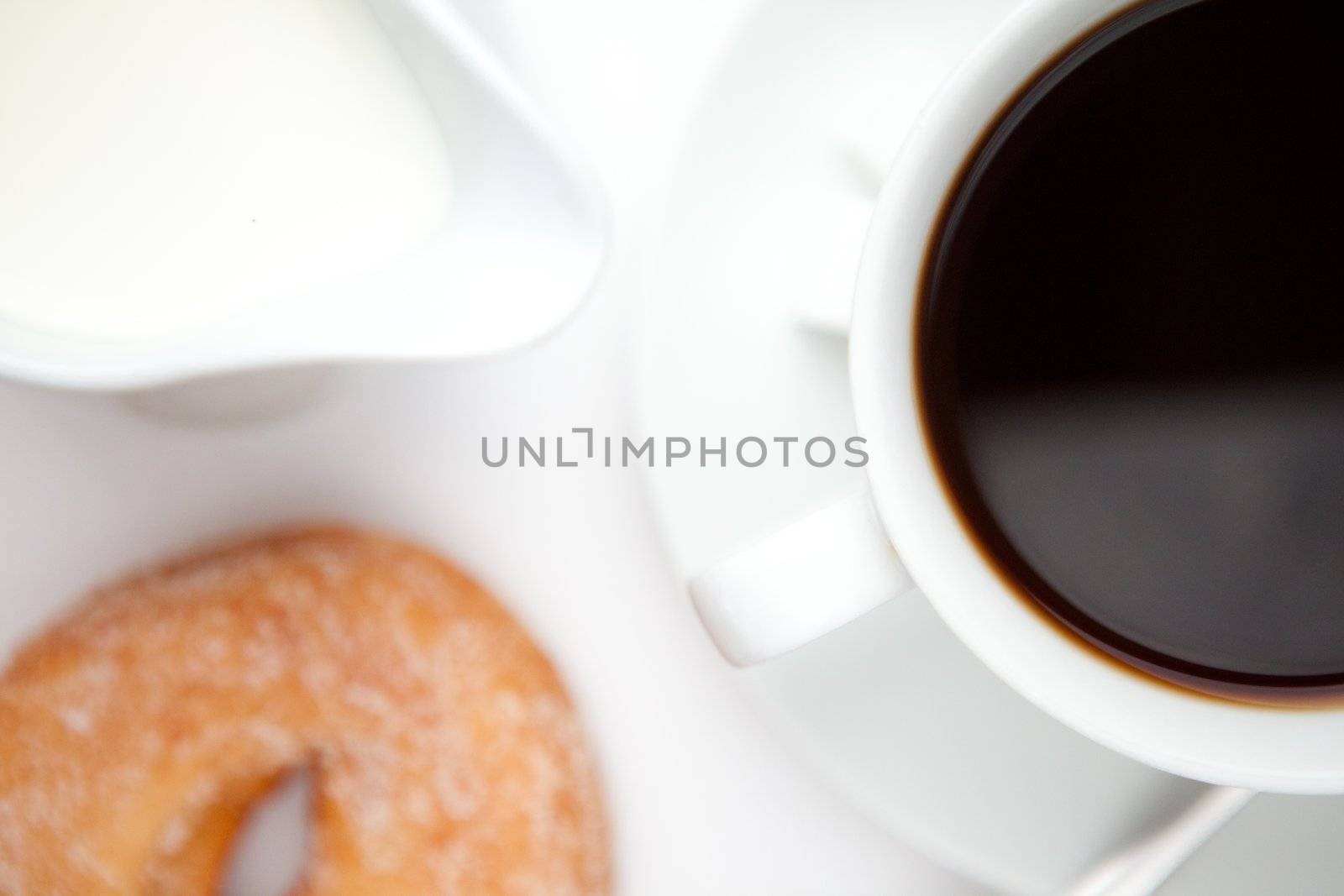 Espresso with doughnut against a white background
