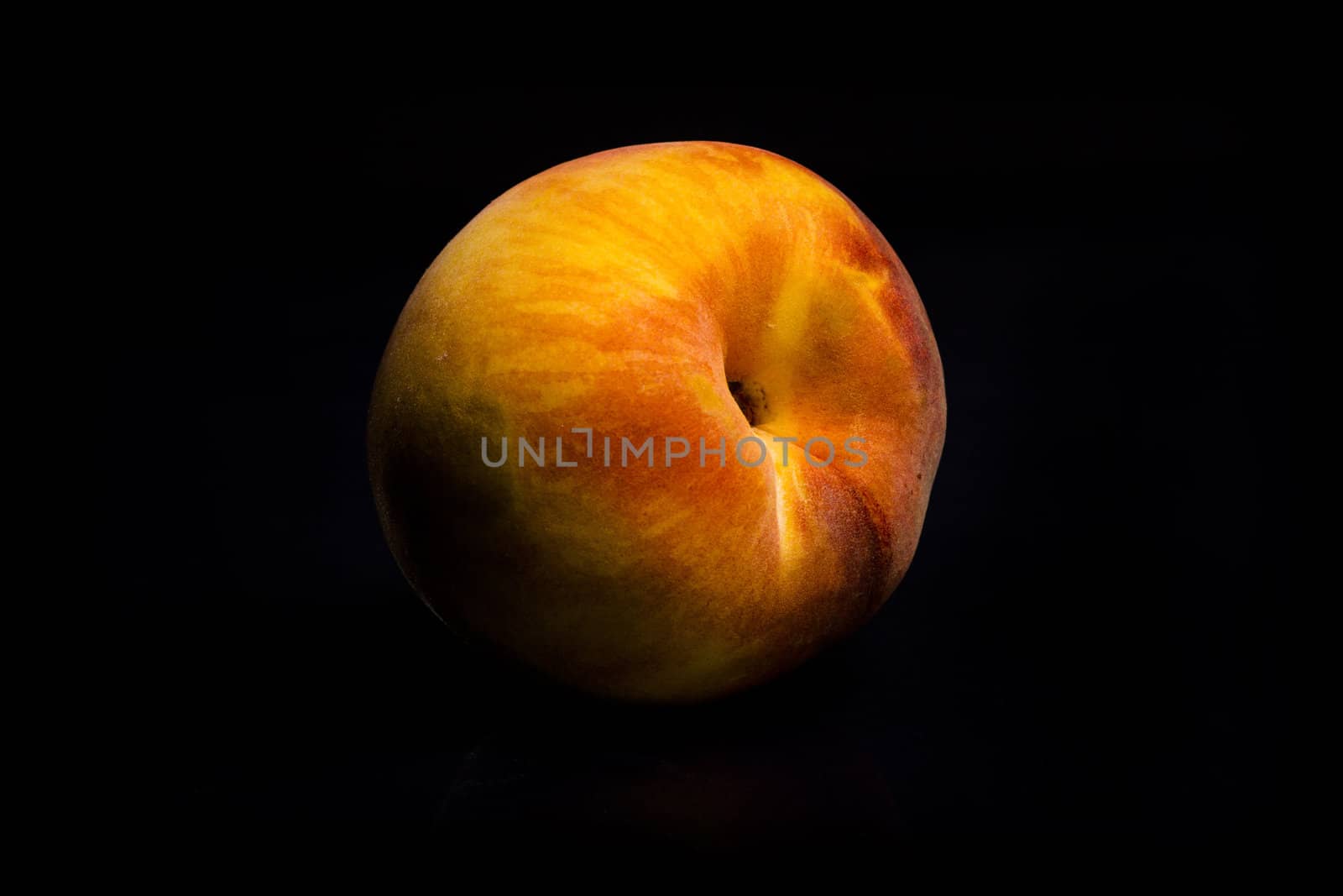 One fresh Peach on black background with reflection