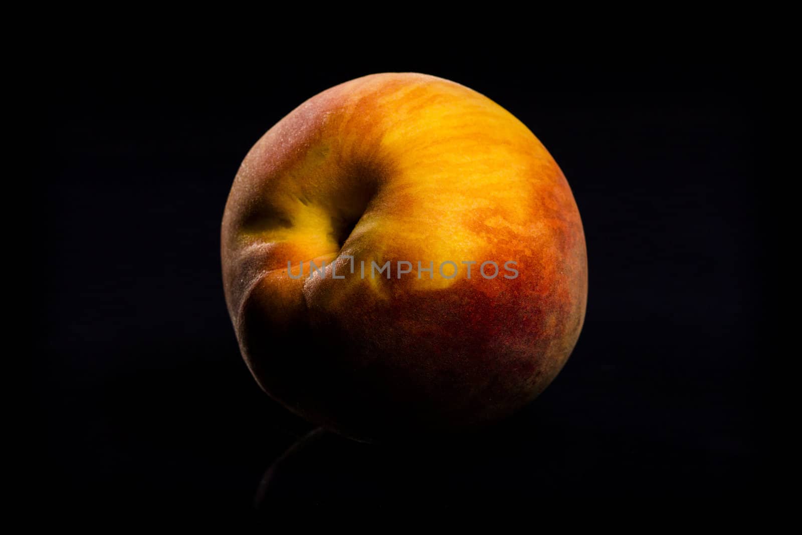 One fresh Peach on black background with reflection