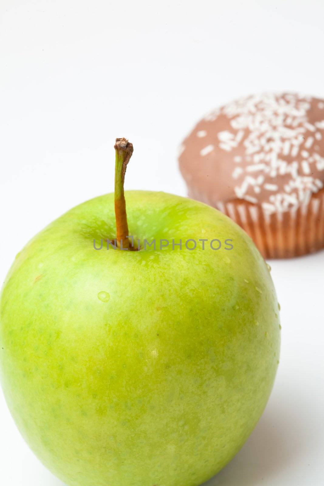 Muffin and apple against a white background