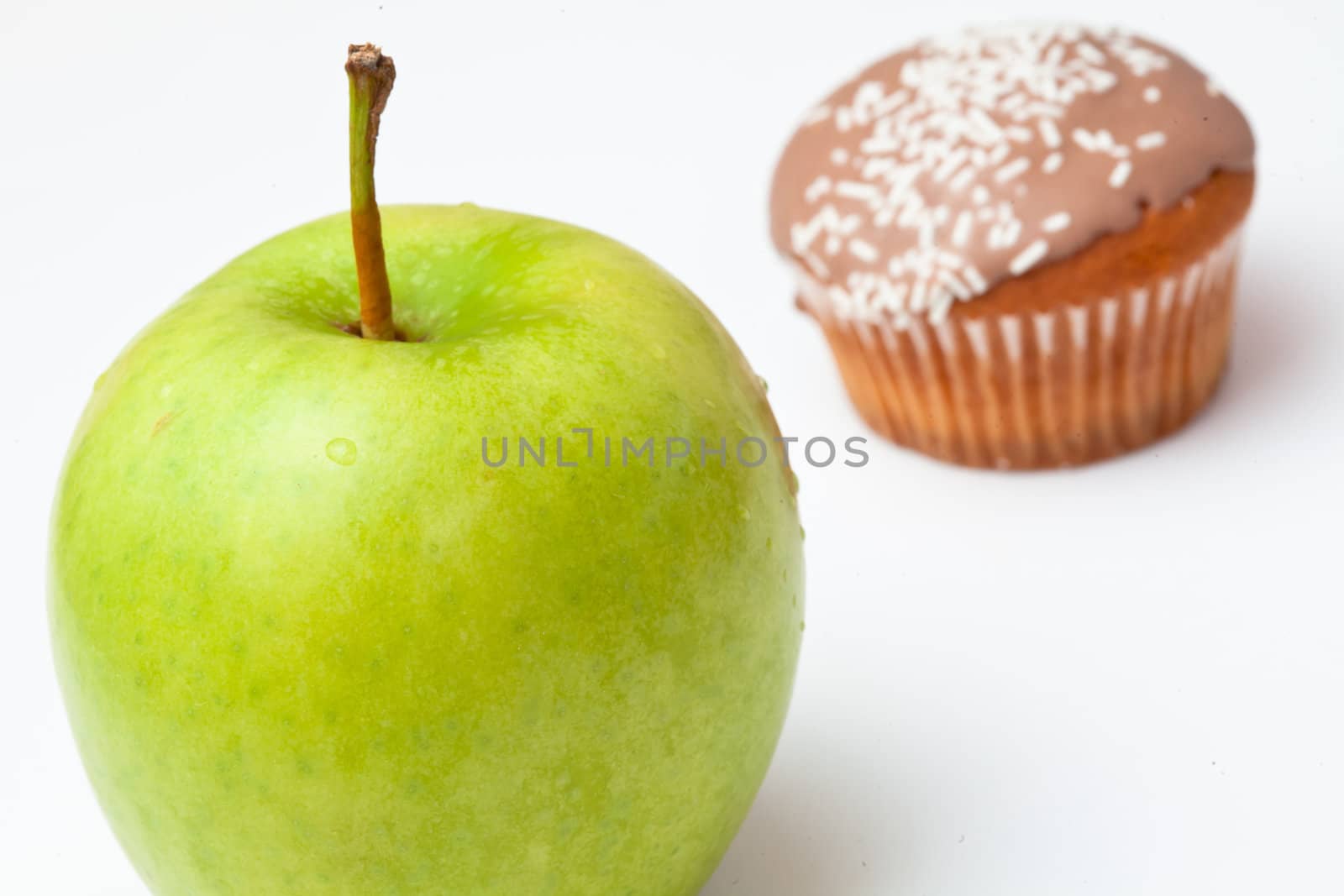 Apple and cupcake against a white background