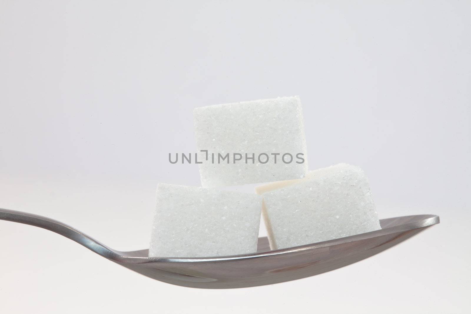 Spoon with sugar against white background