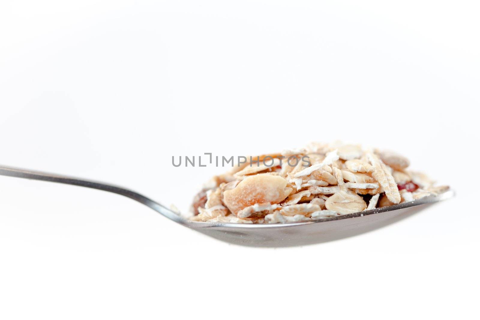 Spoon with muesli on a white background