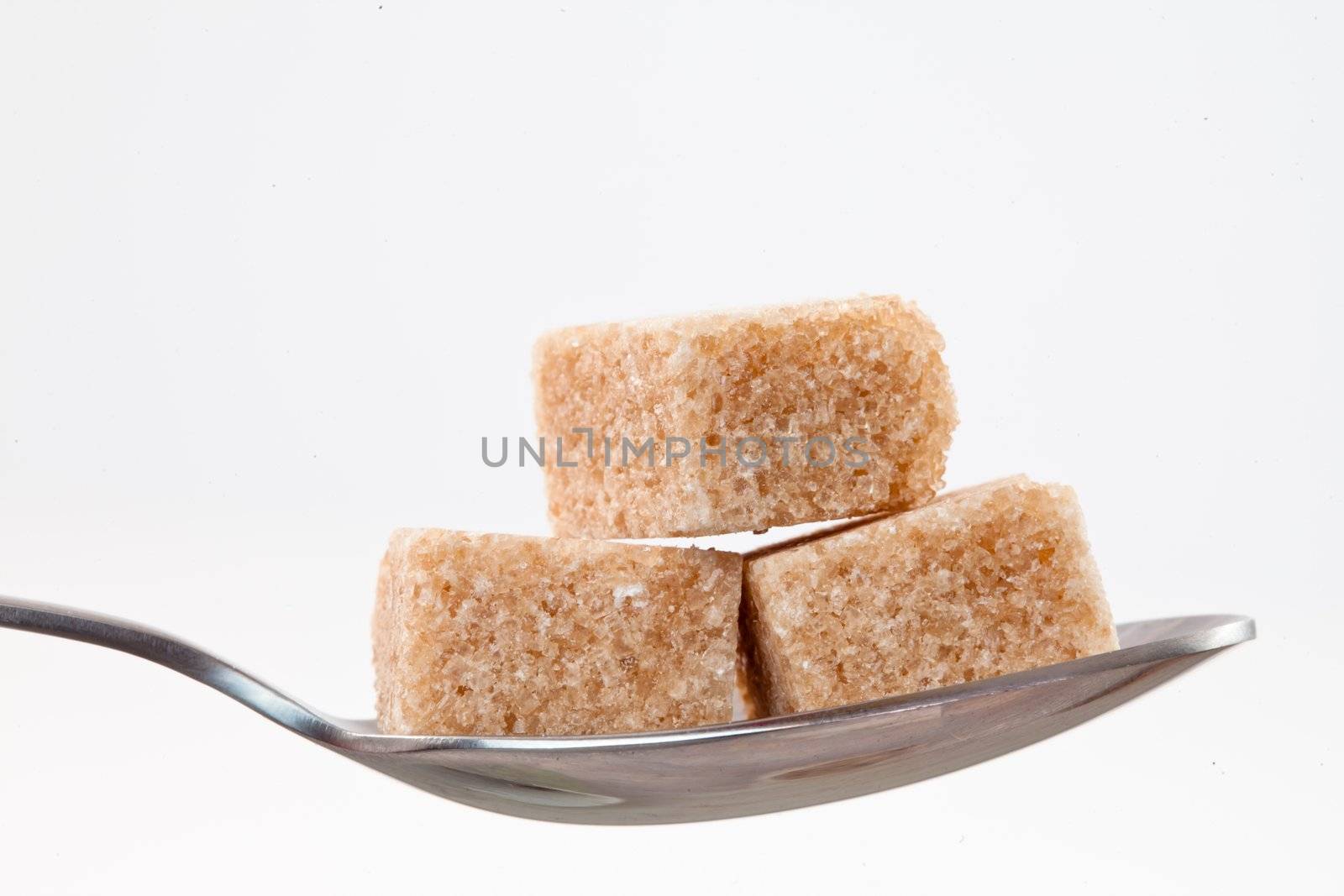 Spoon with  brown sugar against white background