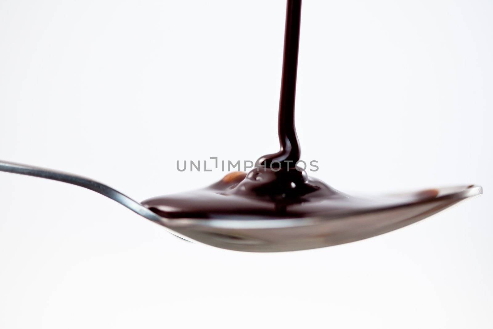 Spoon with chocolate on a white background