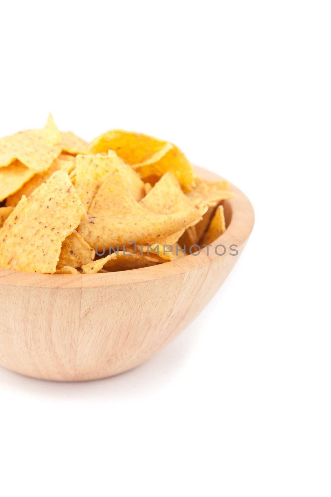 Wooden bowl full of crisps against white background