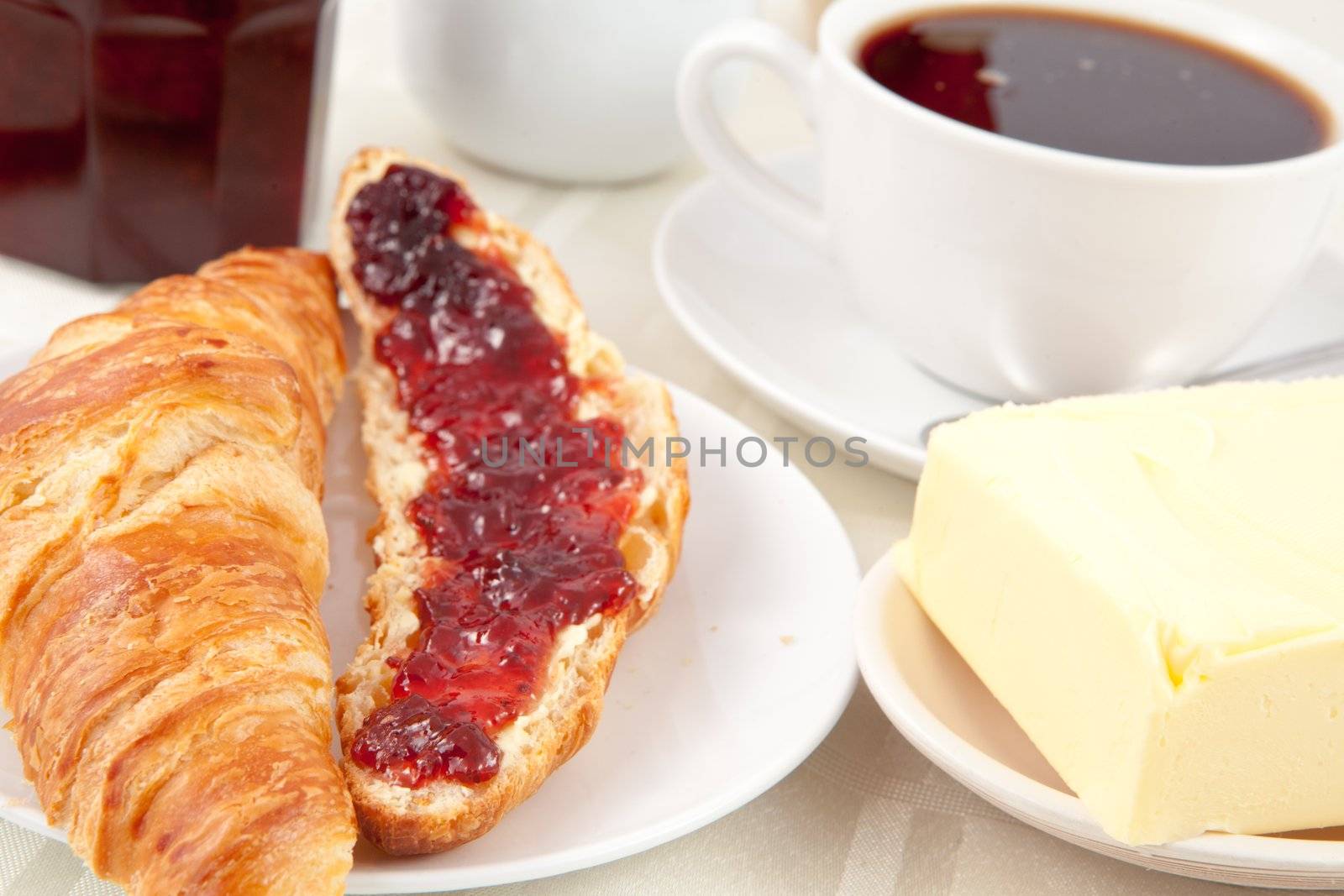 Breakfast with a croissant spread with jam indoors