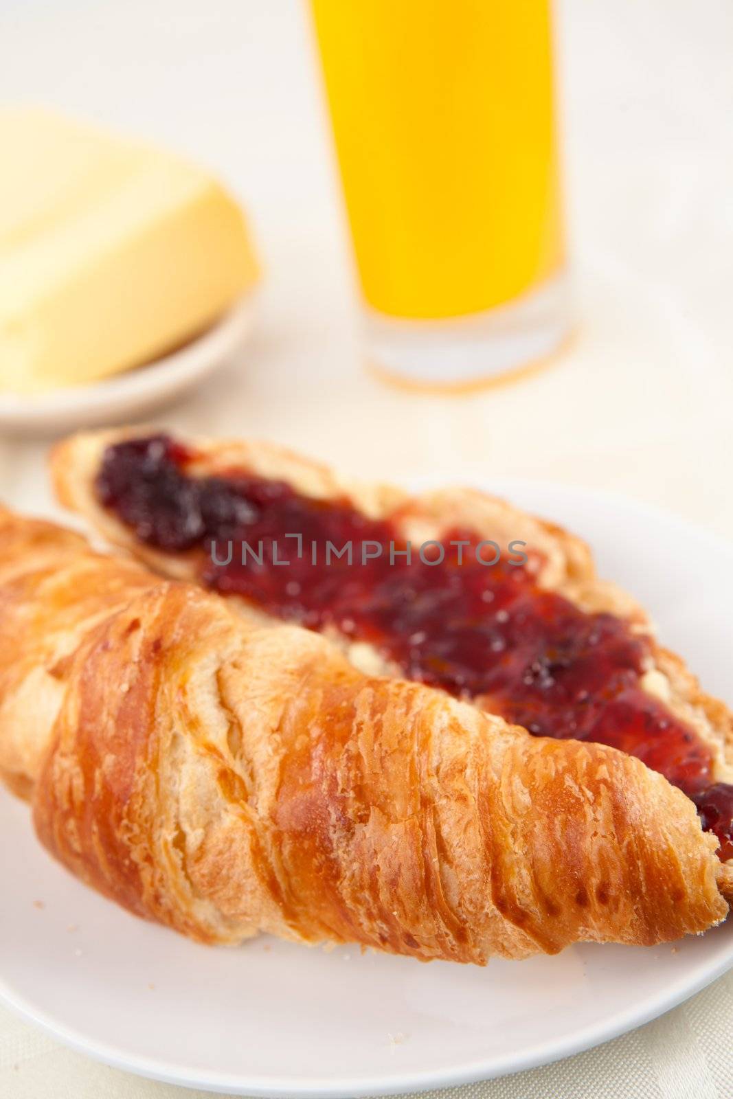 Croissant in front of a glass of orange juice on a table