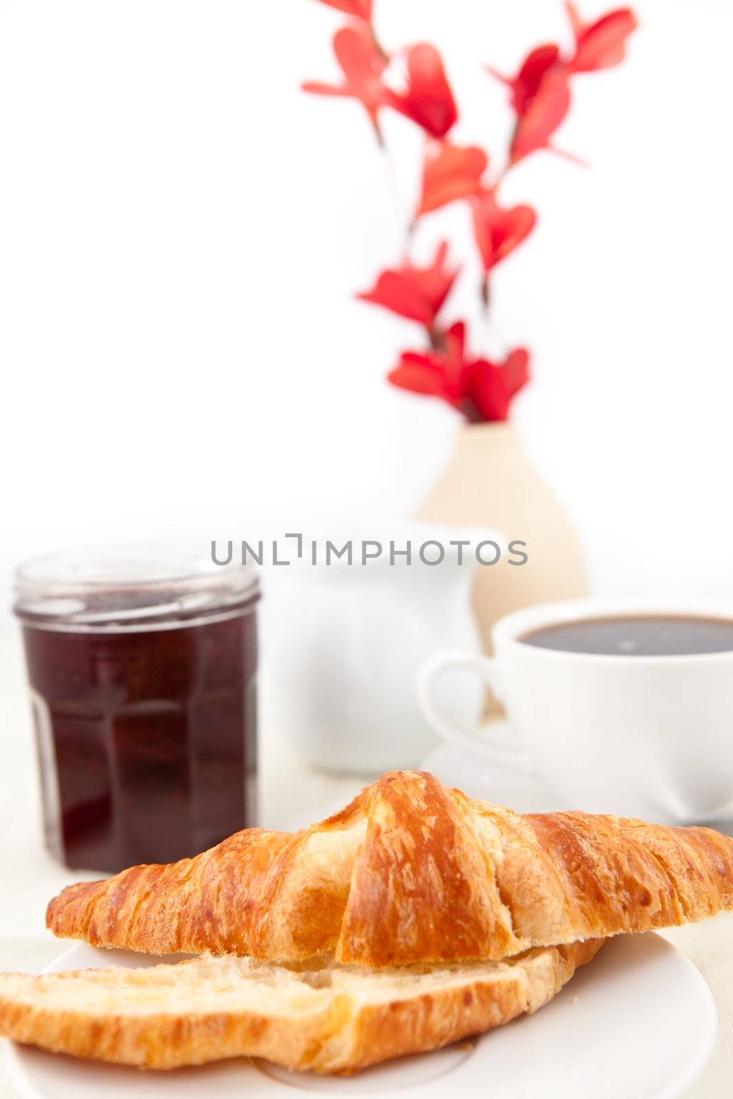 Breakfast with a bisected croissant  against white background