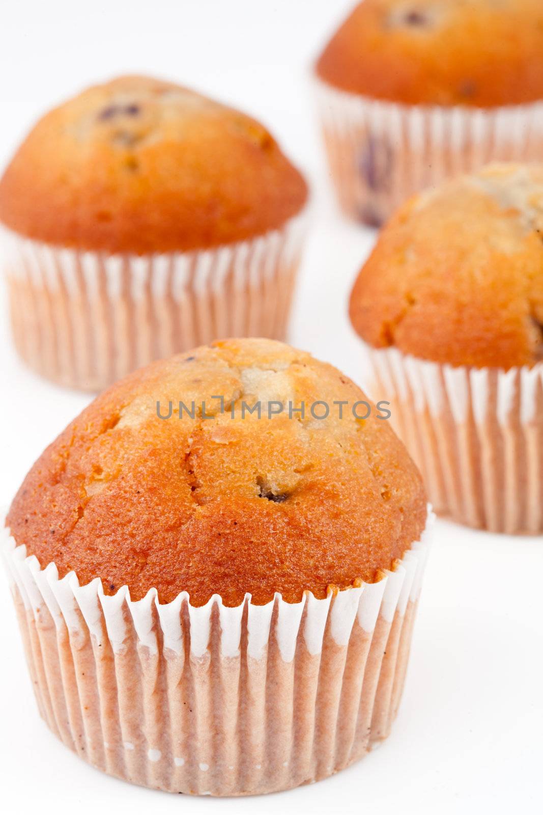 Four small baked muffins against a white background