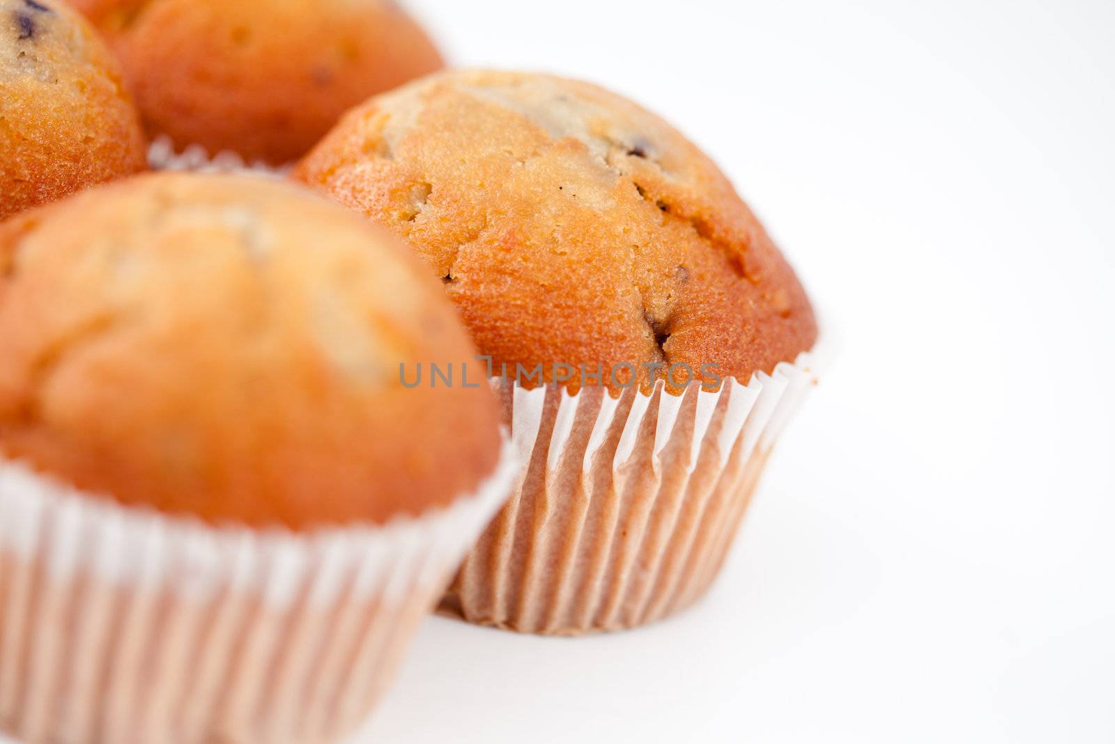 Small blurred muffins against a white background