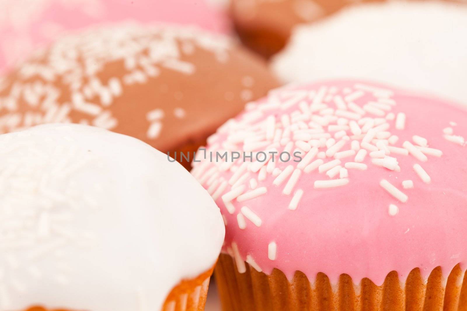 Many muffins with icing sugar against a white background