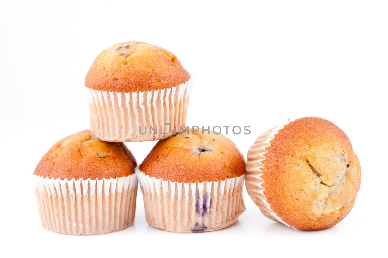 Muffins piled up against a white background