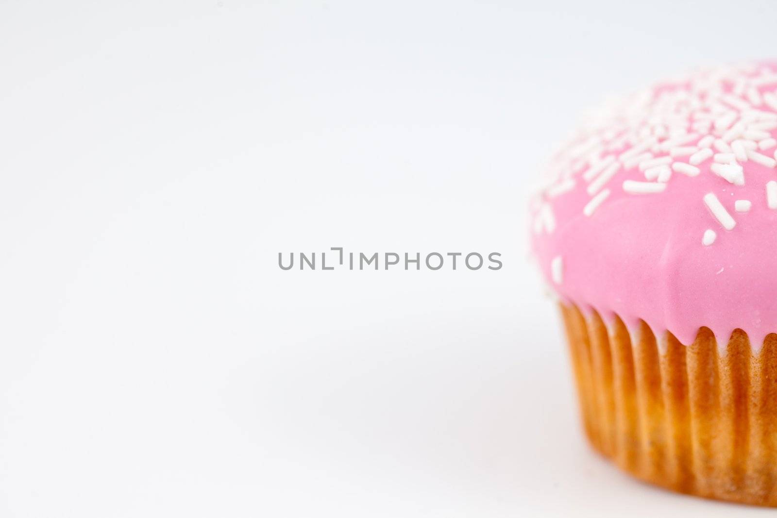 Close up on a muffin with icing sugar against a white background