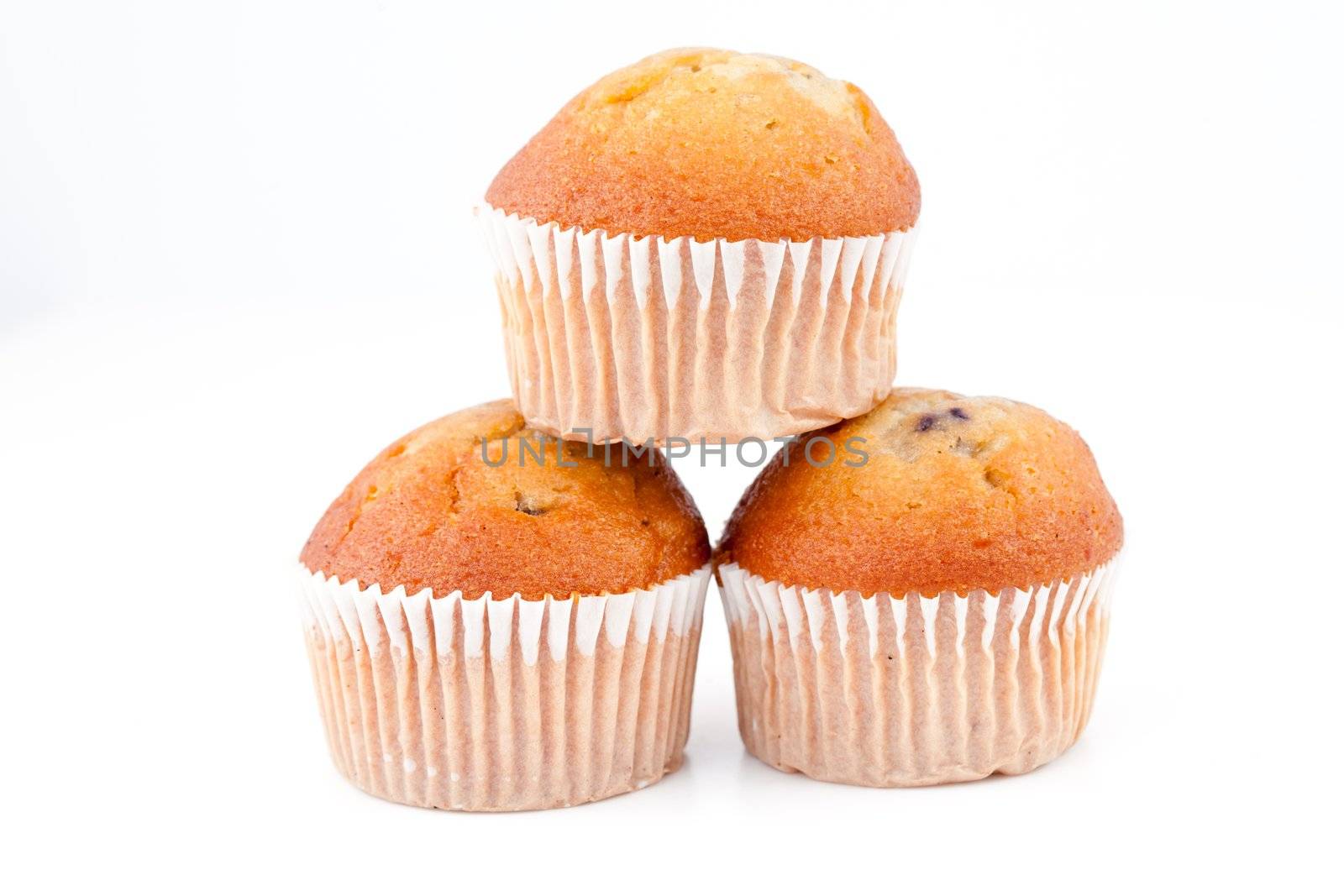 Three muffins piled up against a white back ground