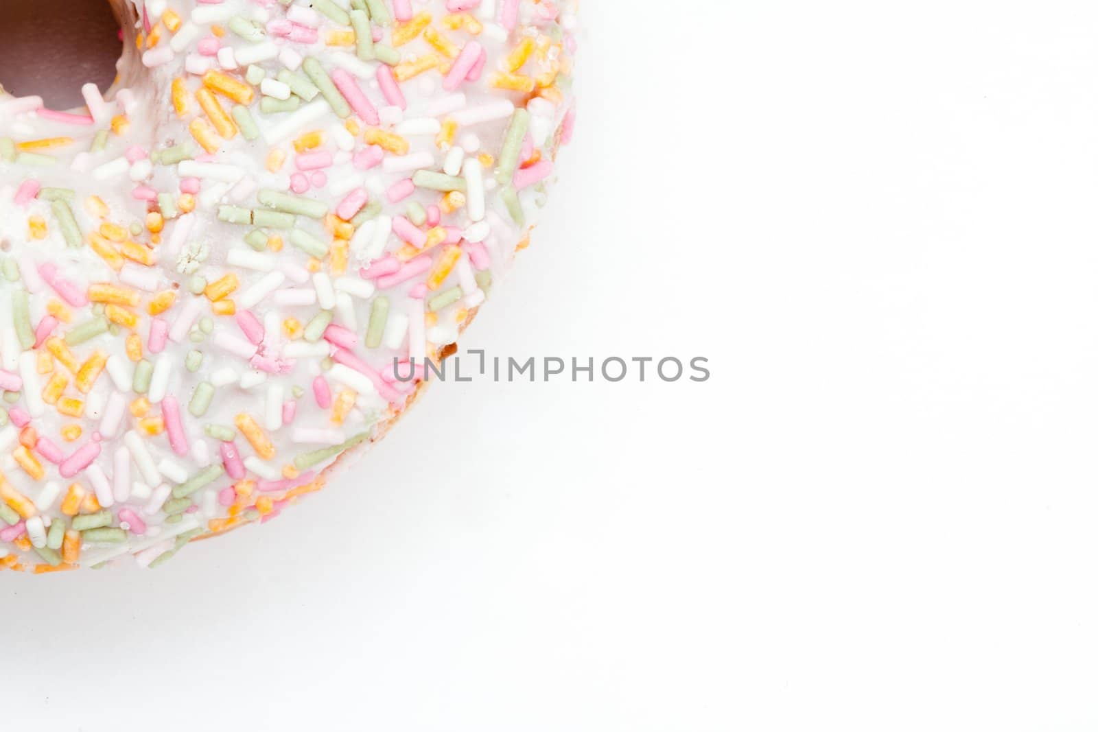 Close up of a doughnut with icing sugar against a white background