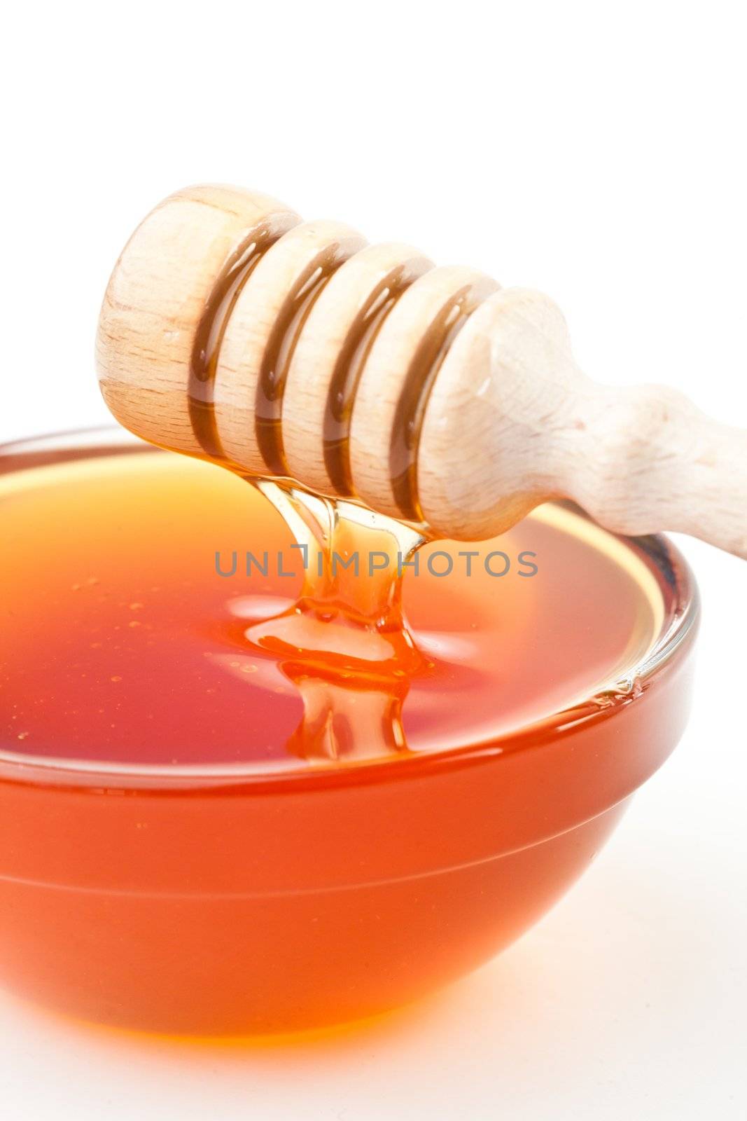 Honey sticky trickle dropping in a honey bowl by Wavebreakmedia