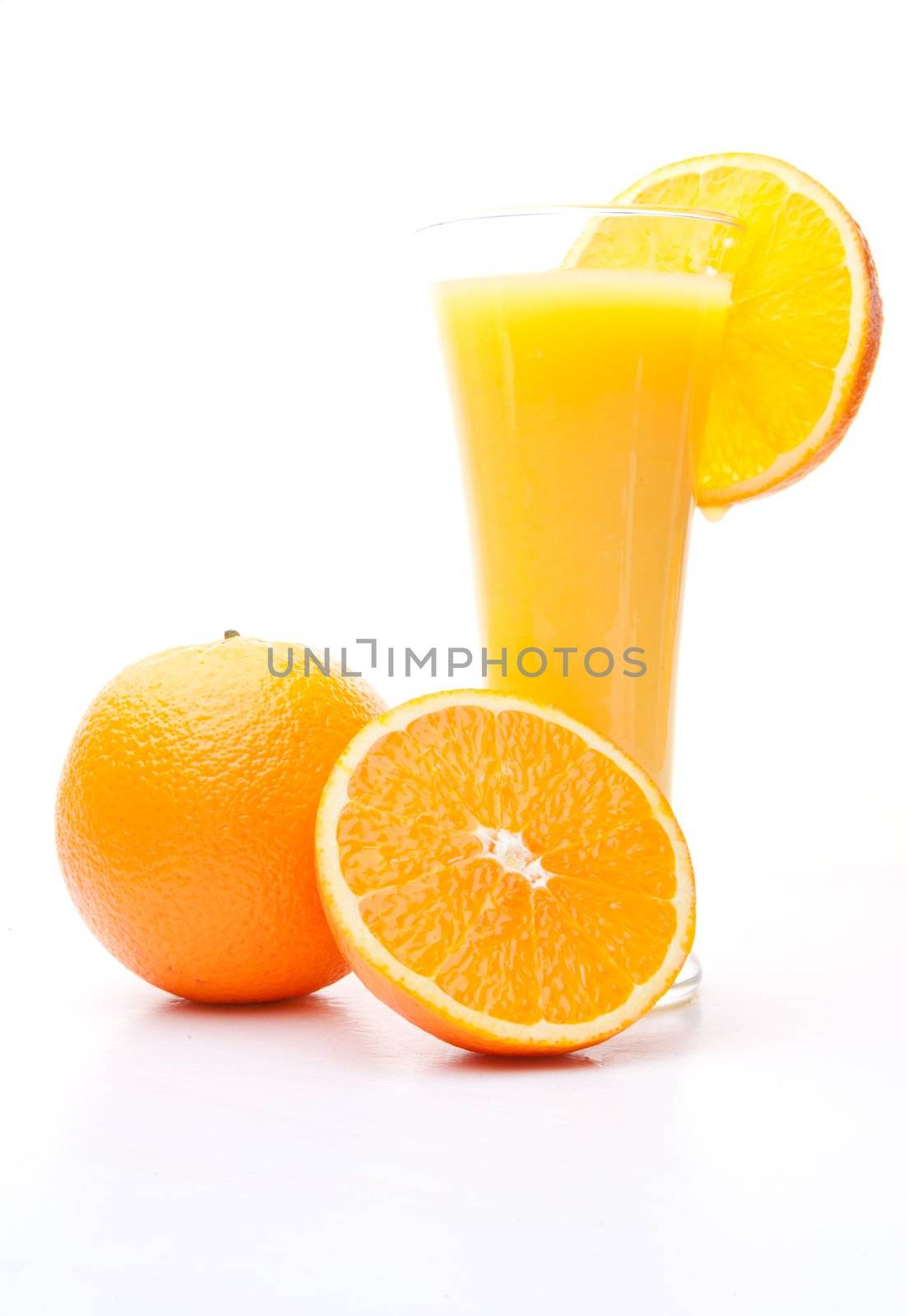 One orange and a half near a glass of orange juice by Wavebreakmedia