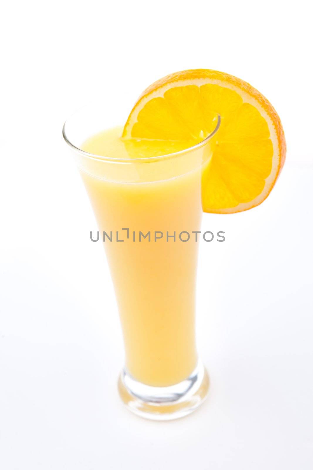 Full glass of orange juice with orange slice against white background