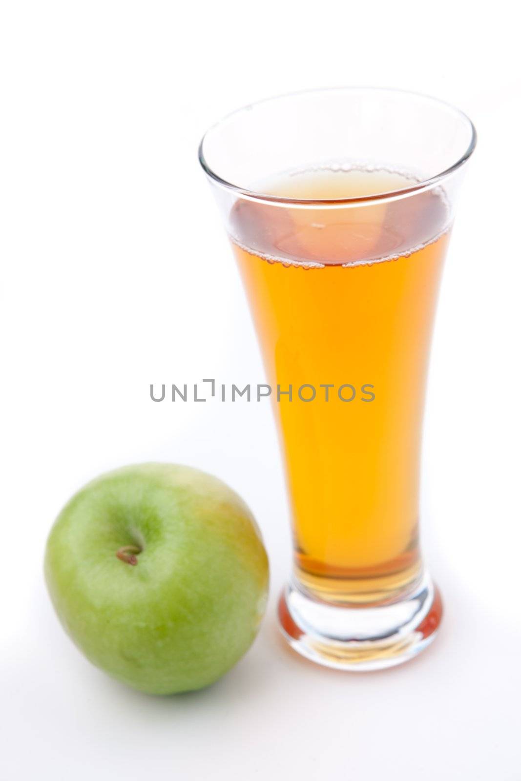 Apple place near a glass of apple juice against white background